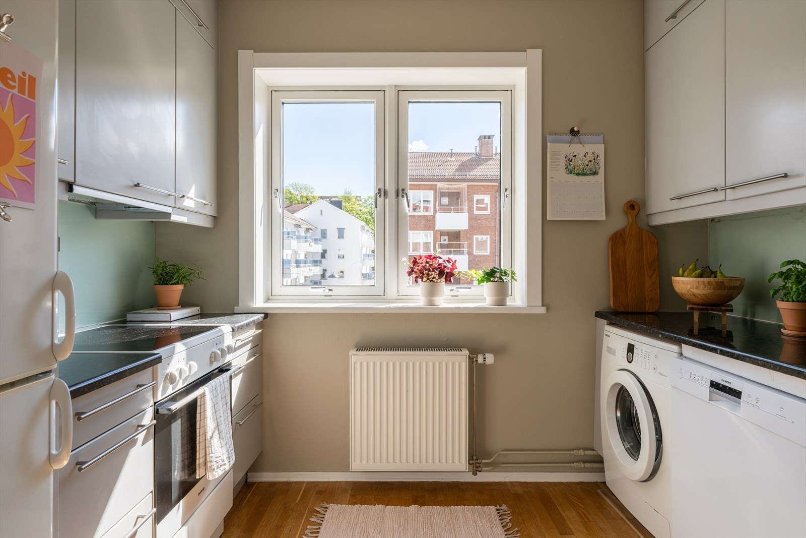 Pent og lyst separat kjøkken, med fronter i en behagelig gråtone. Veggene er malt i en grålig beige farge som bidrar til en lun og koselig atmosfære. Galleribilde