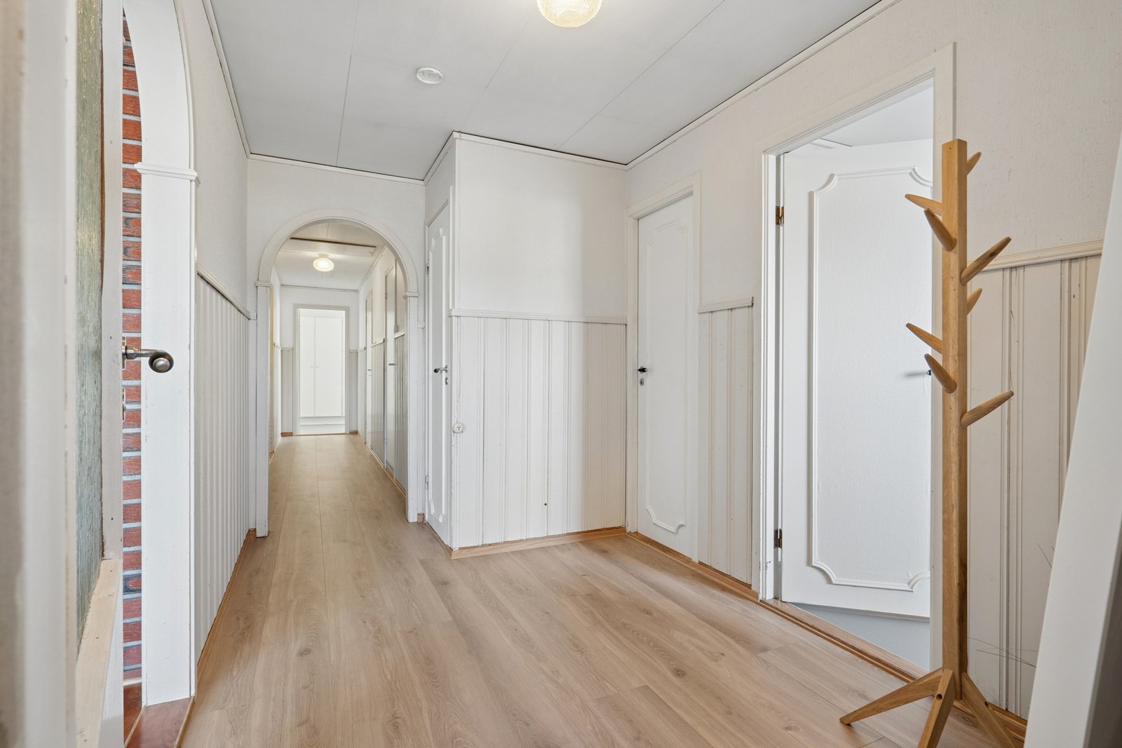 En dør med glassfelt forbinder entréen med den sentrale gangen. Galleribilde