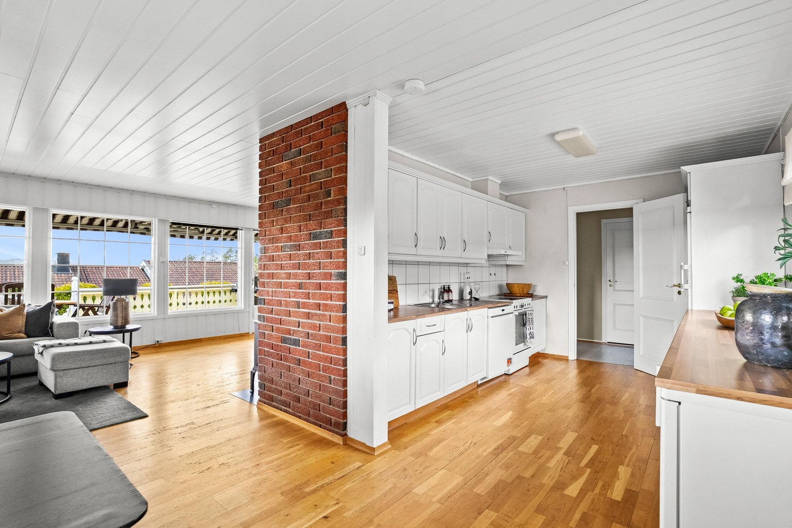 Kjøkkeninnredning med glatte fronter, laminat benkeplate med nedfelt kum i rustfritt stål, benkebeslag i rustfritt stål med utslagskum og kum og ventilator. Galleribilde