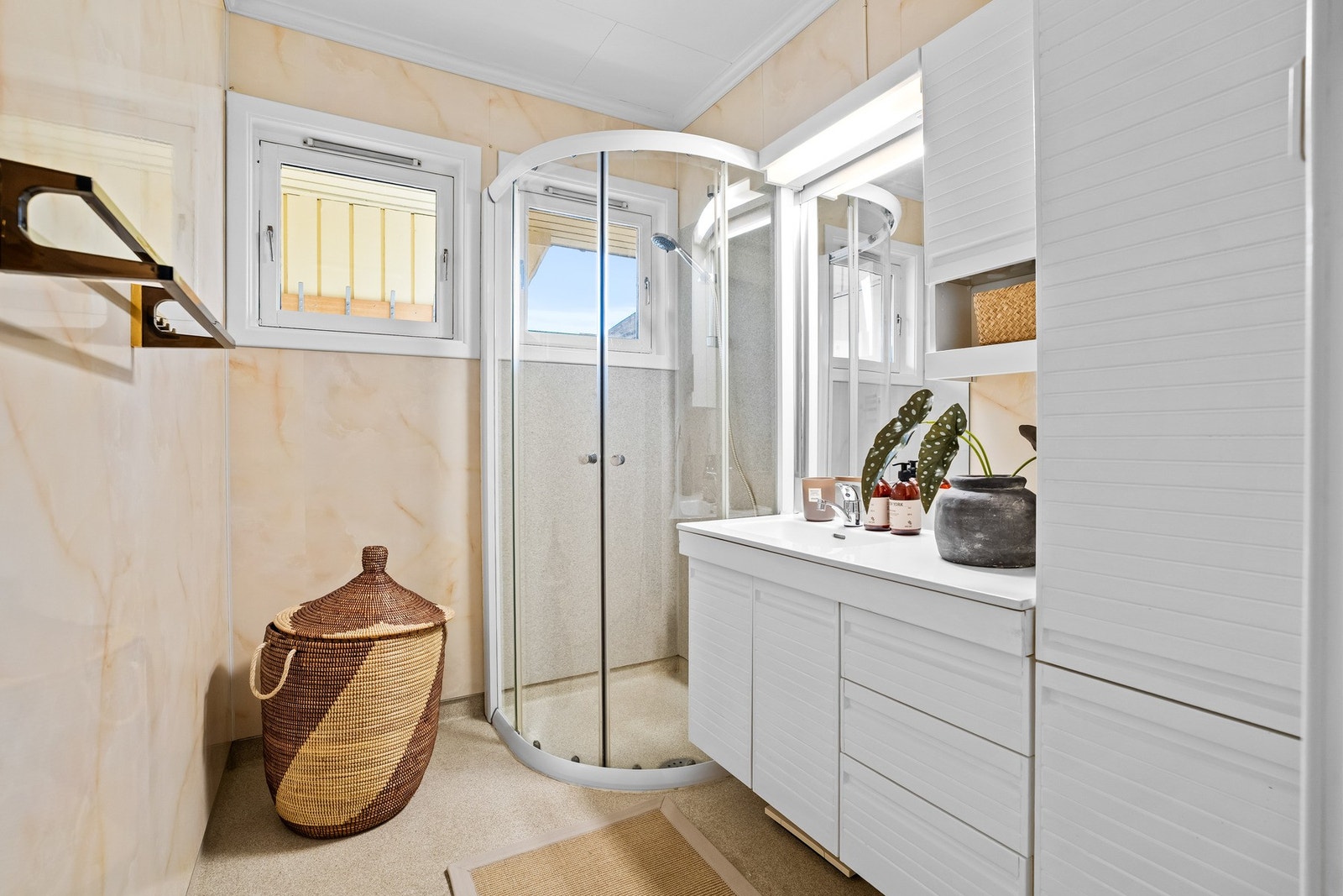 Badet er pusset opp rundt år 2000. Baderomsinnredning bestående av benkeskap, veggskap og høyskap med profilerte fronter, samt dusjkabinett og servant. Galleribilde