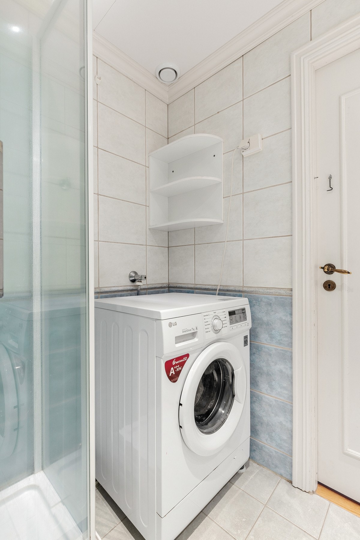 Videre har badet dusjkabinett, opplegg for vaskemaskin og mekanisk avtrekk med ventil i himling Galleribilde