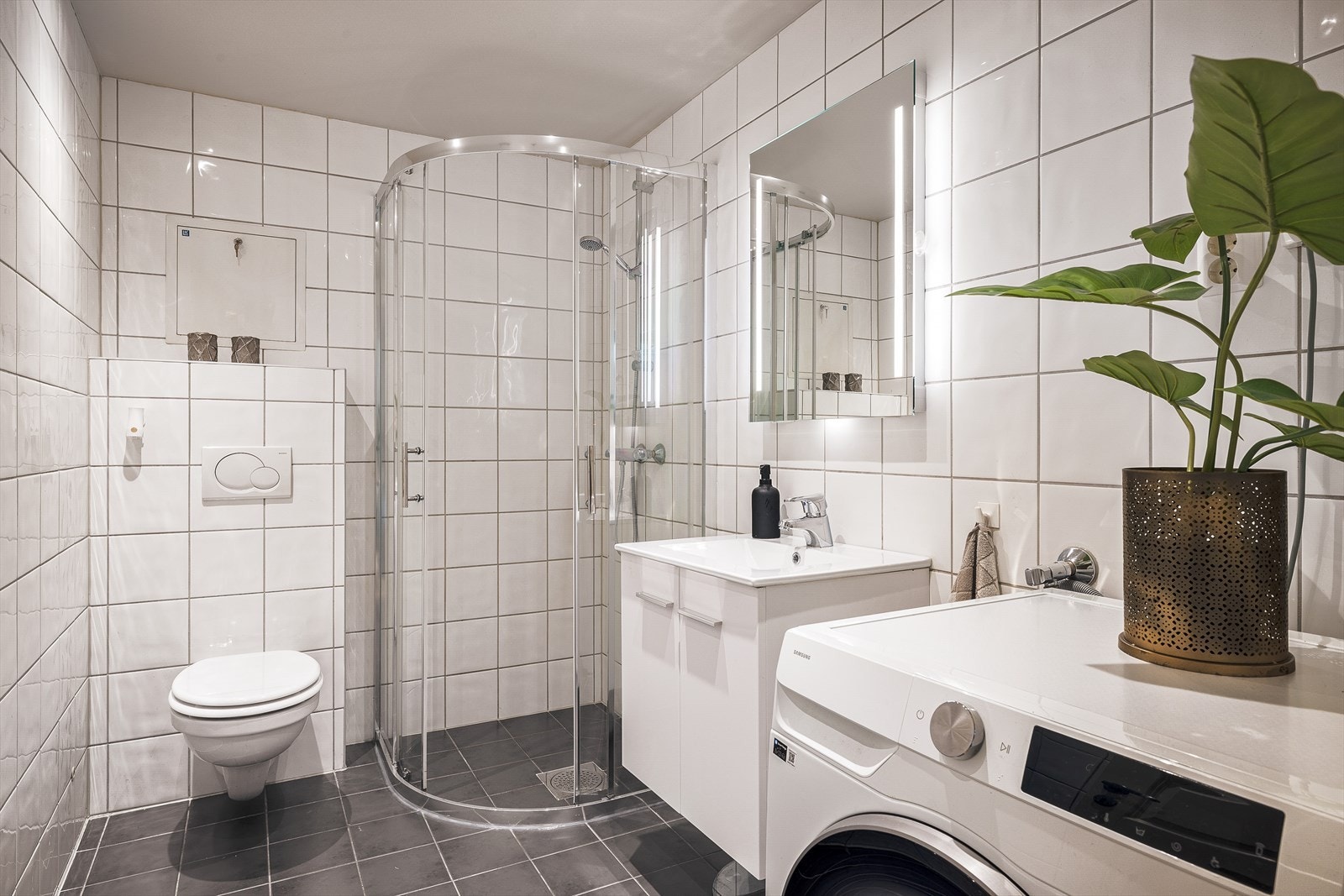 Badet er av veldig grei størrelse på 4,7m² med nye dusjdører, skap og speil Galleribilde