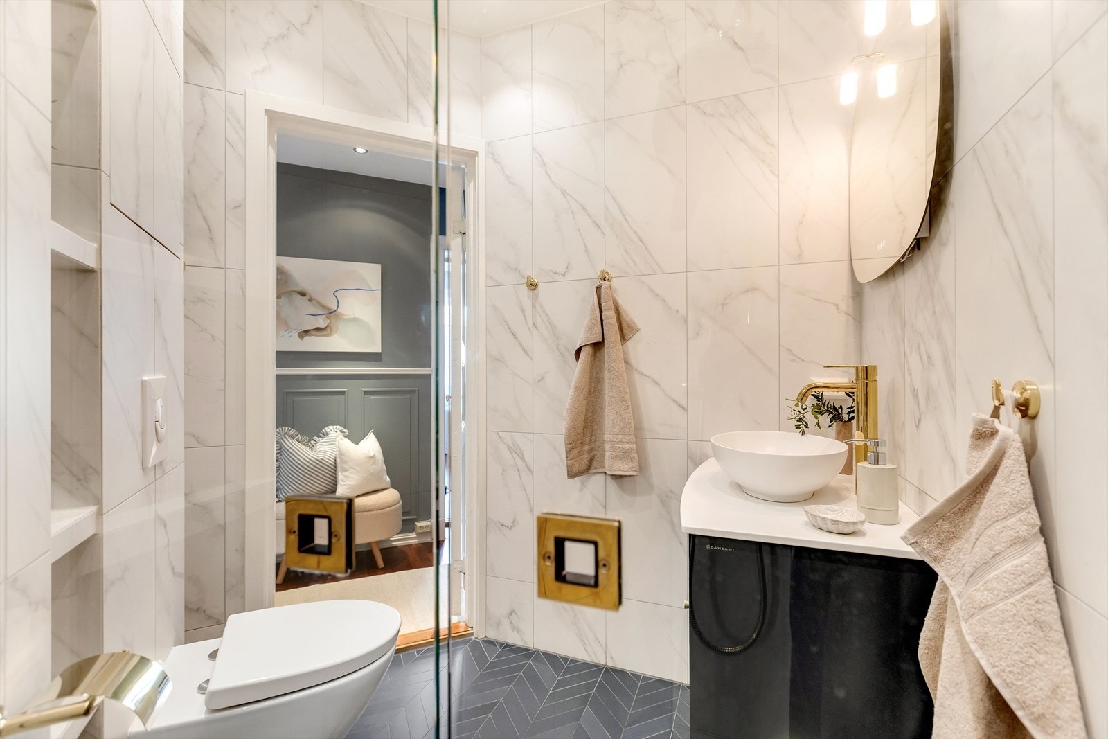 Badet er innredet med vegghengt toalett, dusjsone med glassvegger og innfellbare løsninger, samt servantinnredning med bolleservant og ettgreps blandebatteri. Galleribilde
