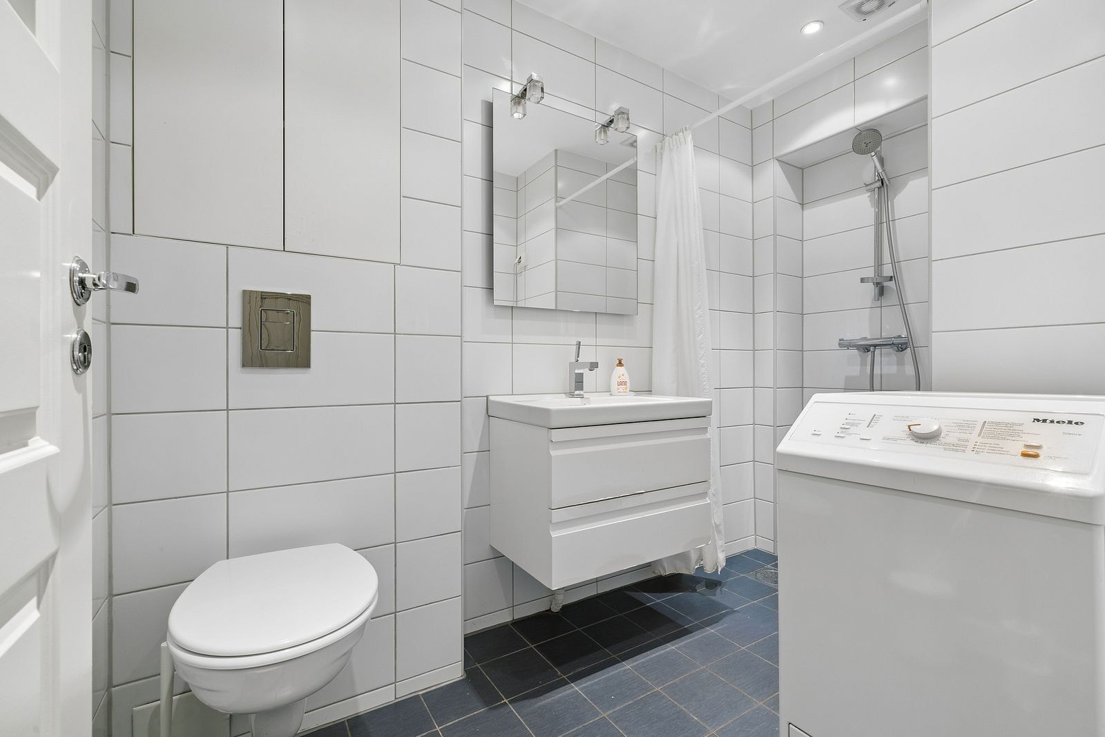 Flislagt bad med varmekabler og vaskemaskin. Galleribilde