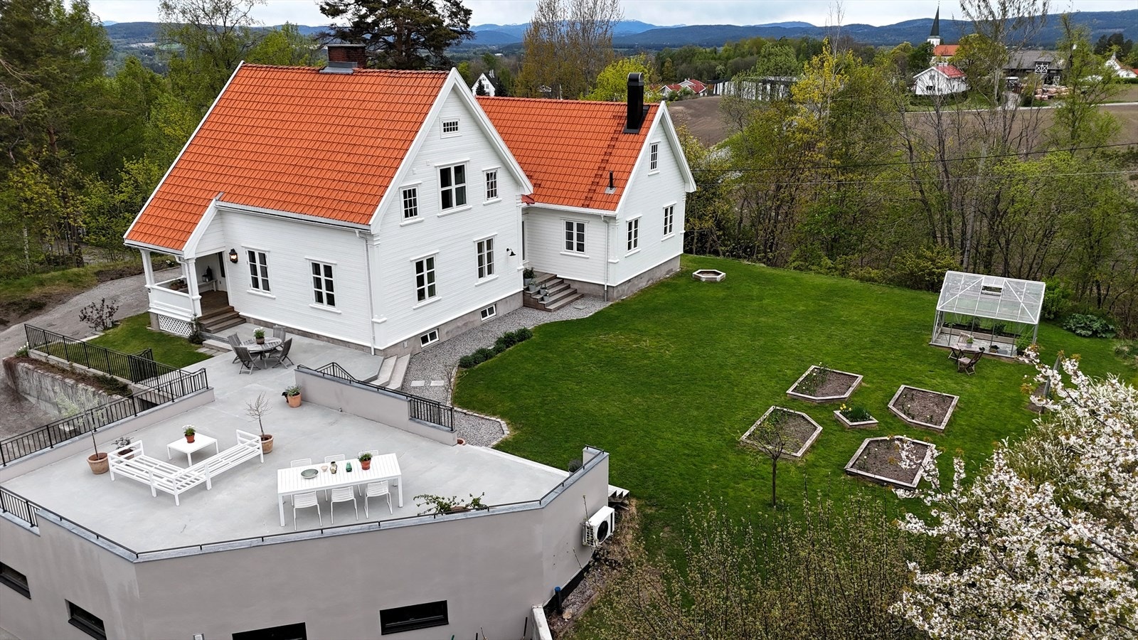 Tomten på hele 1 878 m² er pent opparbeidet med plen og beplantning. Galleribilde