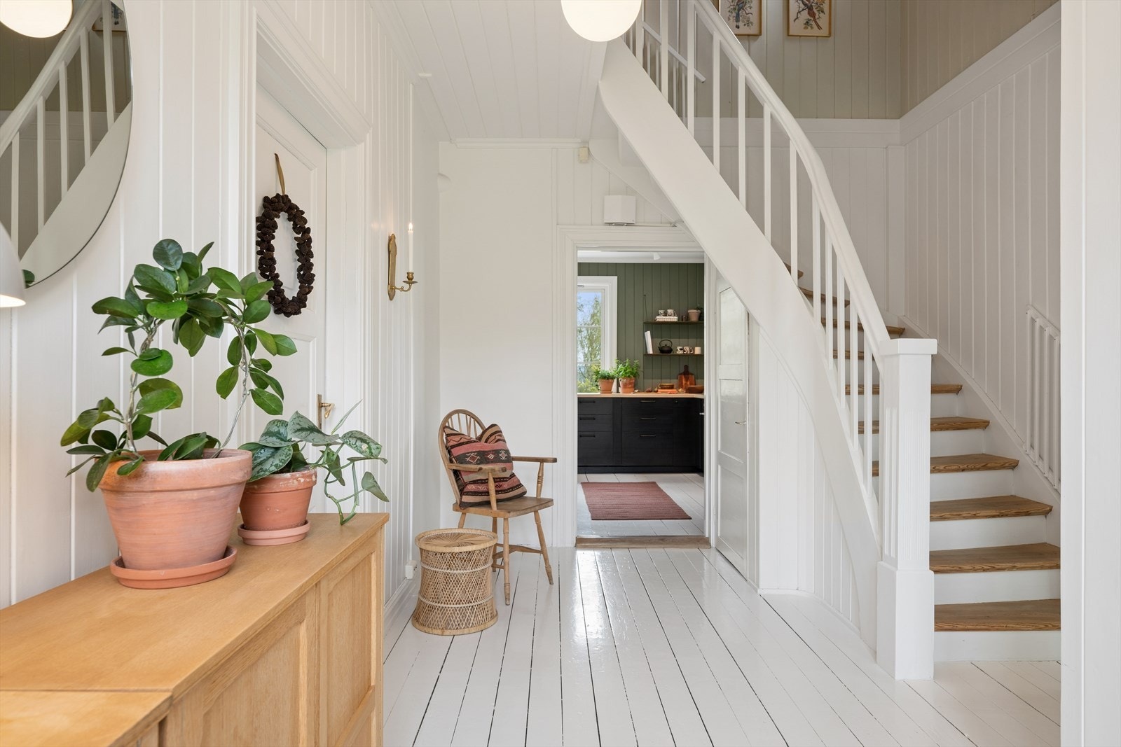 Den malte tretrappen fører opp til loftsetasjen med soverom og bad. Galleribilde