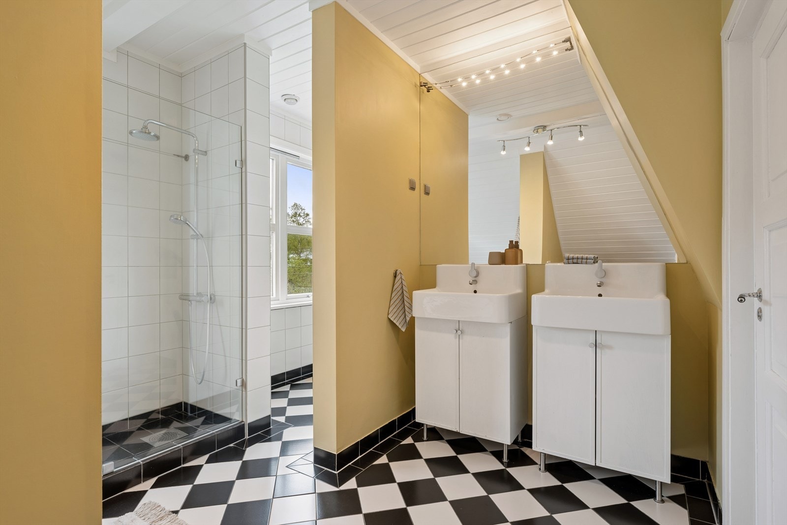 Badet i loftsetasjen har flislagt gulv med varmekabler, dusjhjørne og to servanter. Galleribilde