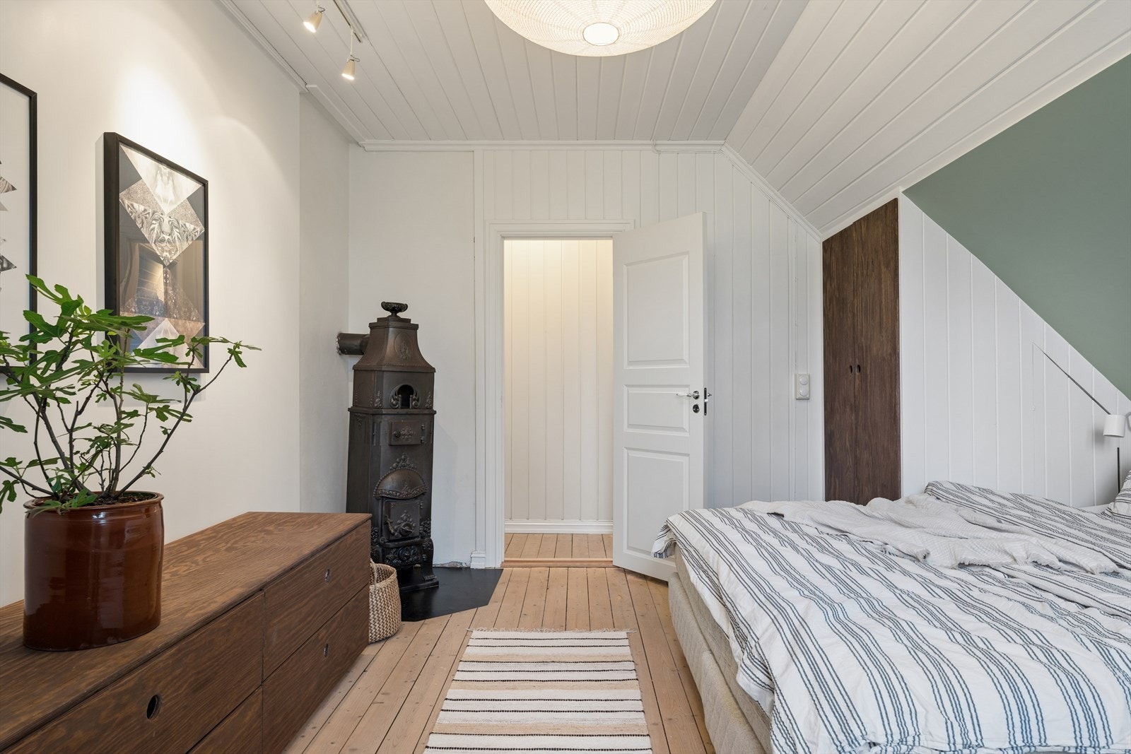 Tidsriktig vedovn på soverommet understreker boligens historiske sjarm og særpreg. Galleribilde