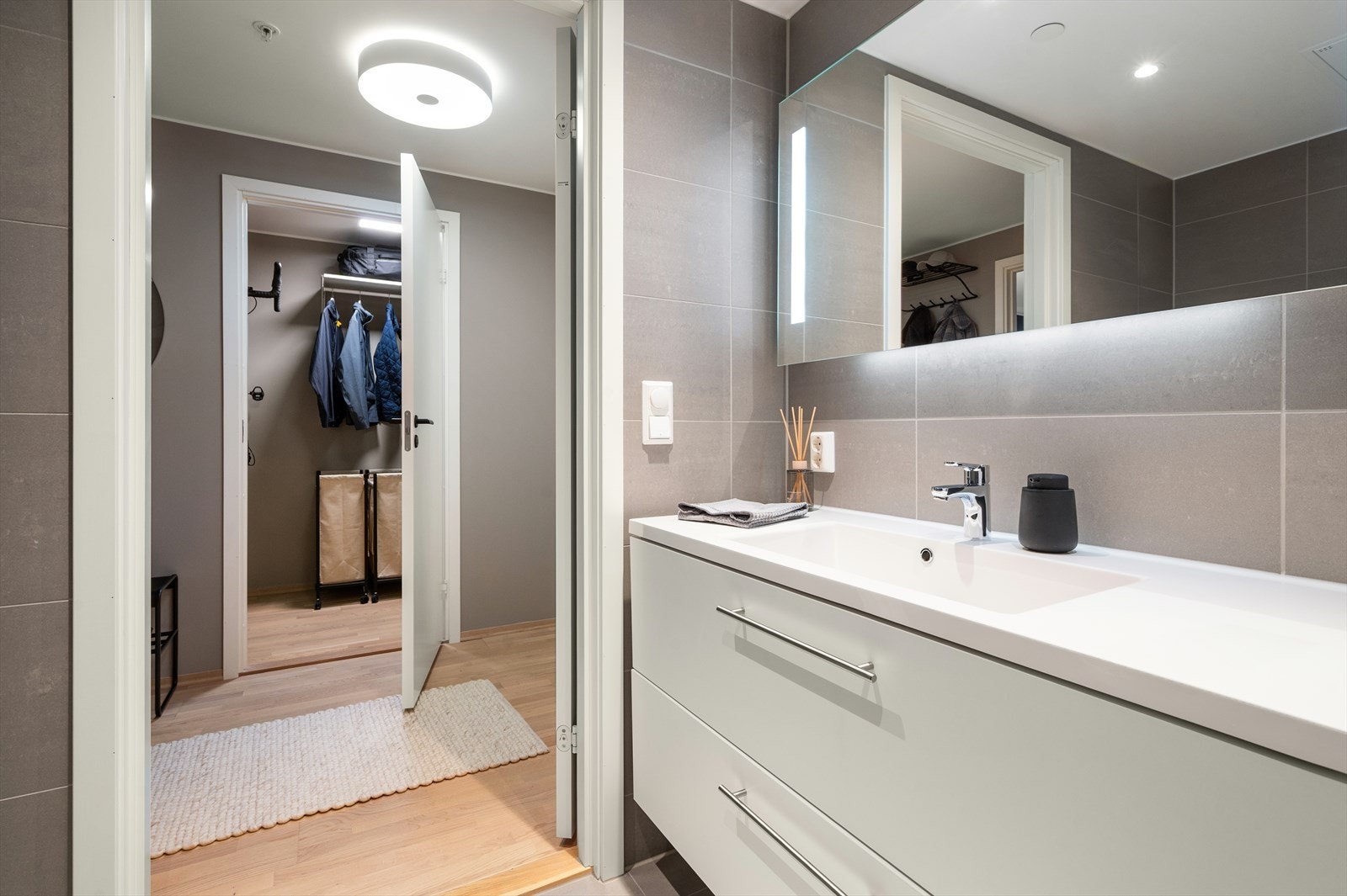 Flislagt gulv med gulvvarme, flislagte vegger og malt himling med downlights. Galleribilde