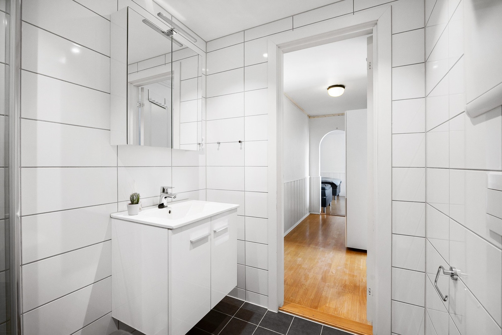 Badet er innredet med vegghengt toalett, dusjnisje, servant og opplegg for vaskemaskin. Galleribilde