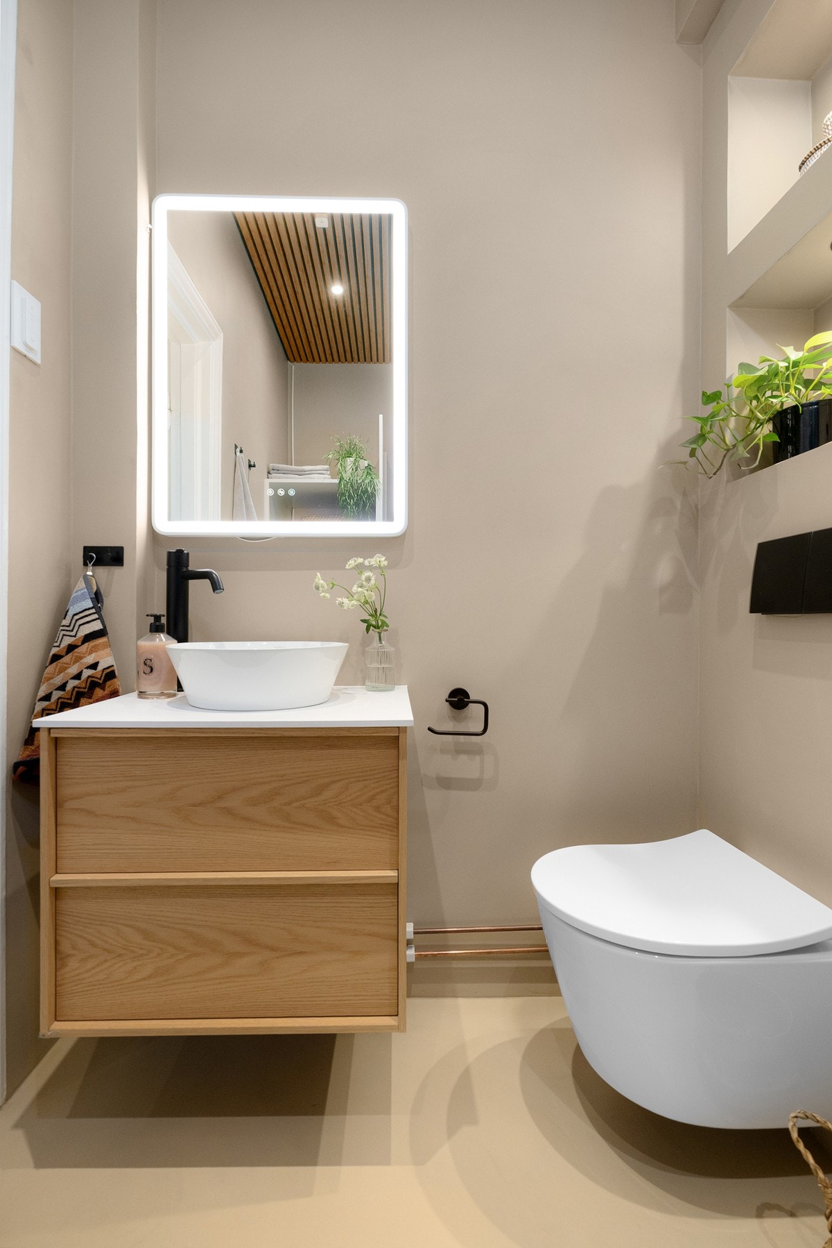 Baderommet har mikrosement på gulv og vegger, elektrisk gulvvarme og trespiler i himlingen med innfelte downlights. Galleribilde