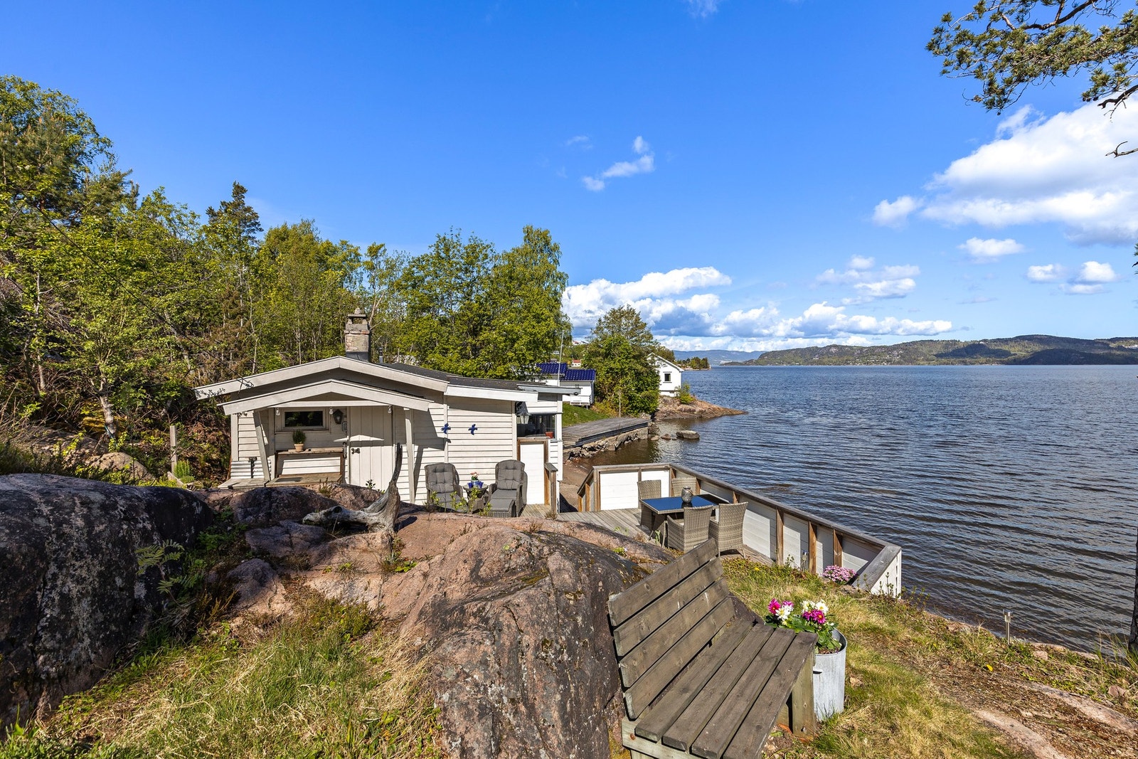 Fritidsboligen har to terrasser oppført i trekonstruksjon og med nydelig fjordutsikt Galleribilde