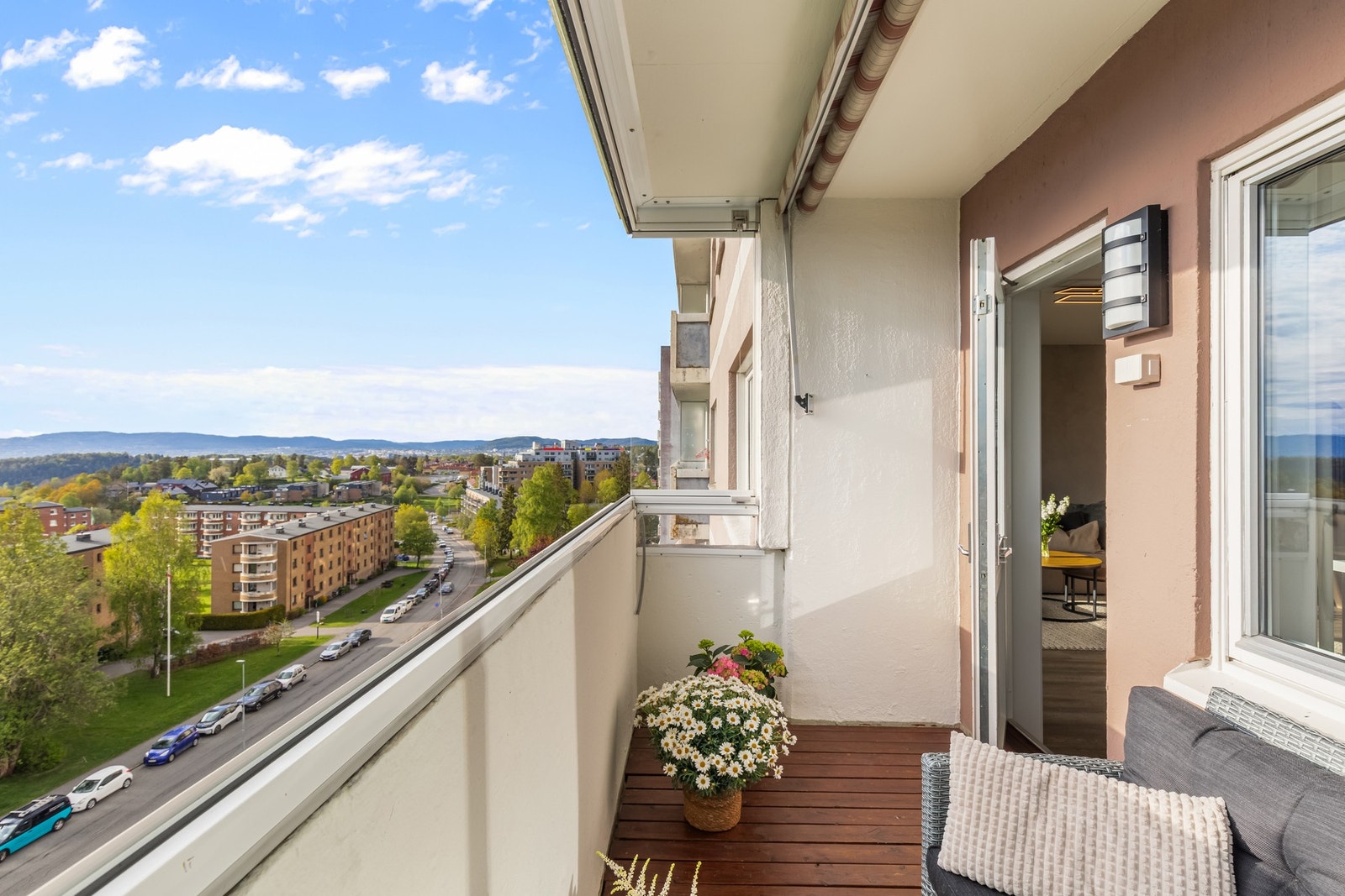 Videre er balkongen utstyrt med utelys, stikkontakt og markise. Og pent dekket med beiset terrassebord på gulvet. Galleribilde