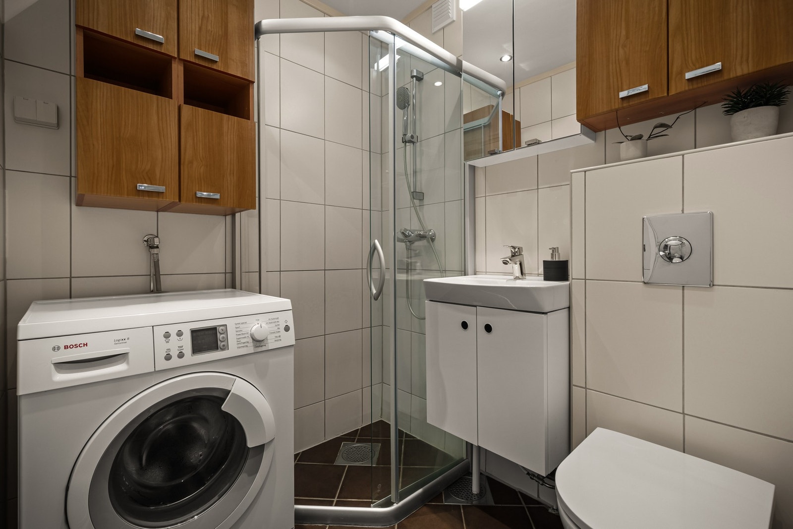 Pent flislagt baderom fra 2006 med varmekabler i gulv og downlights i himling. Badet er utstyrt med dusjhjørne, servant med underskap, speil med belysning og opplegg for vaskemaskin. Galleribilde