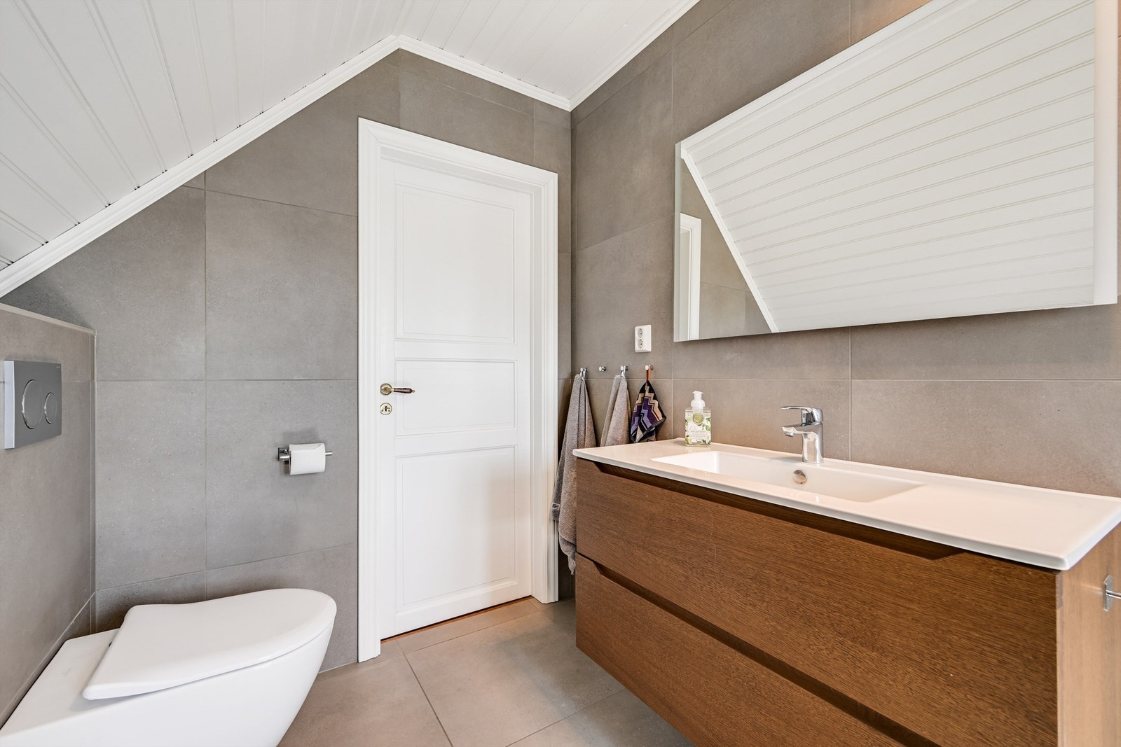 Badet har vegghengt toalett. Galleribilde
