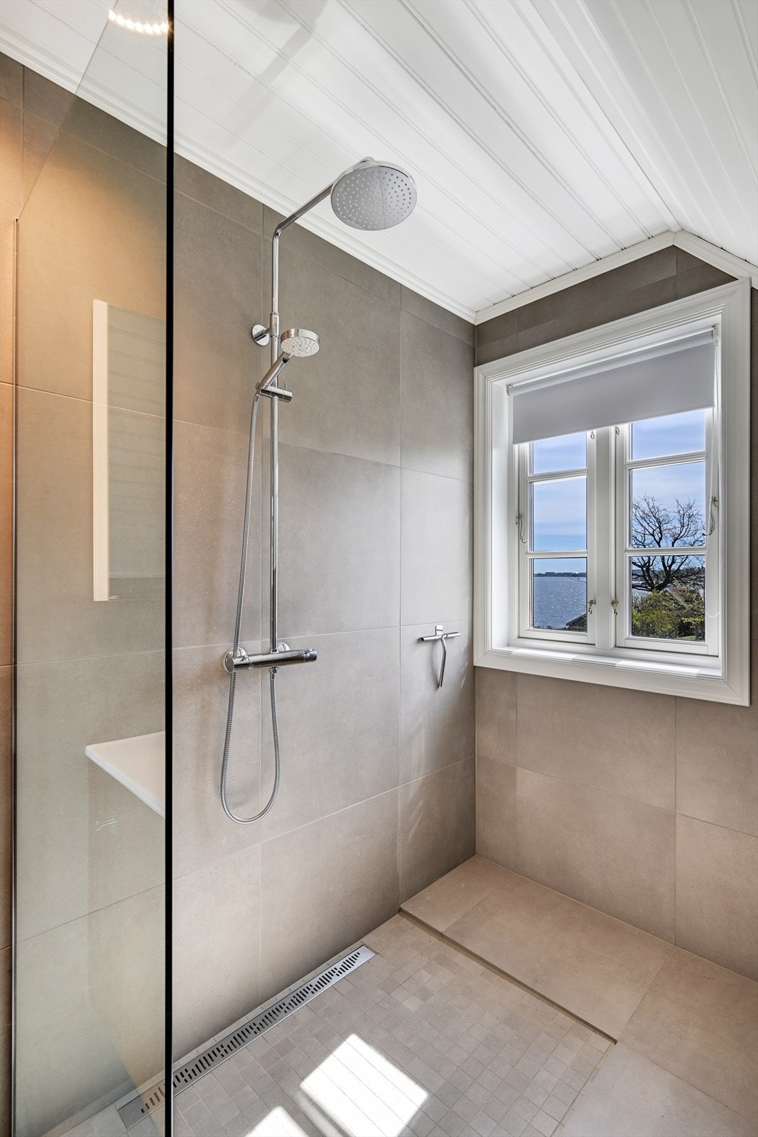 Romslig dusjnisje med glassvegg, regn- og hånddusj. Galleribilde