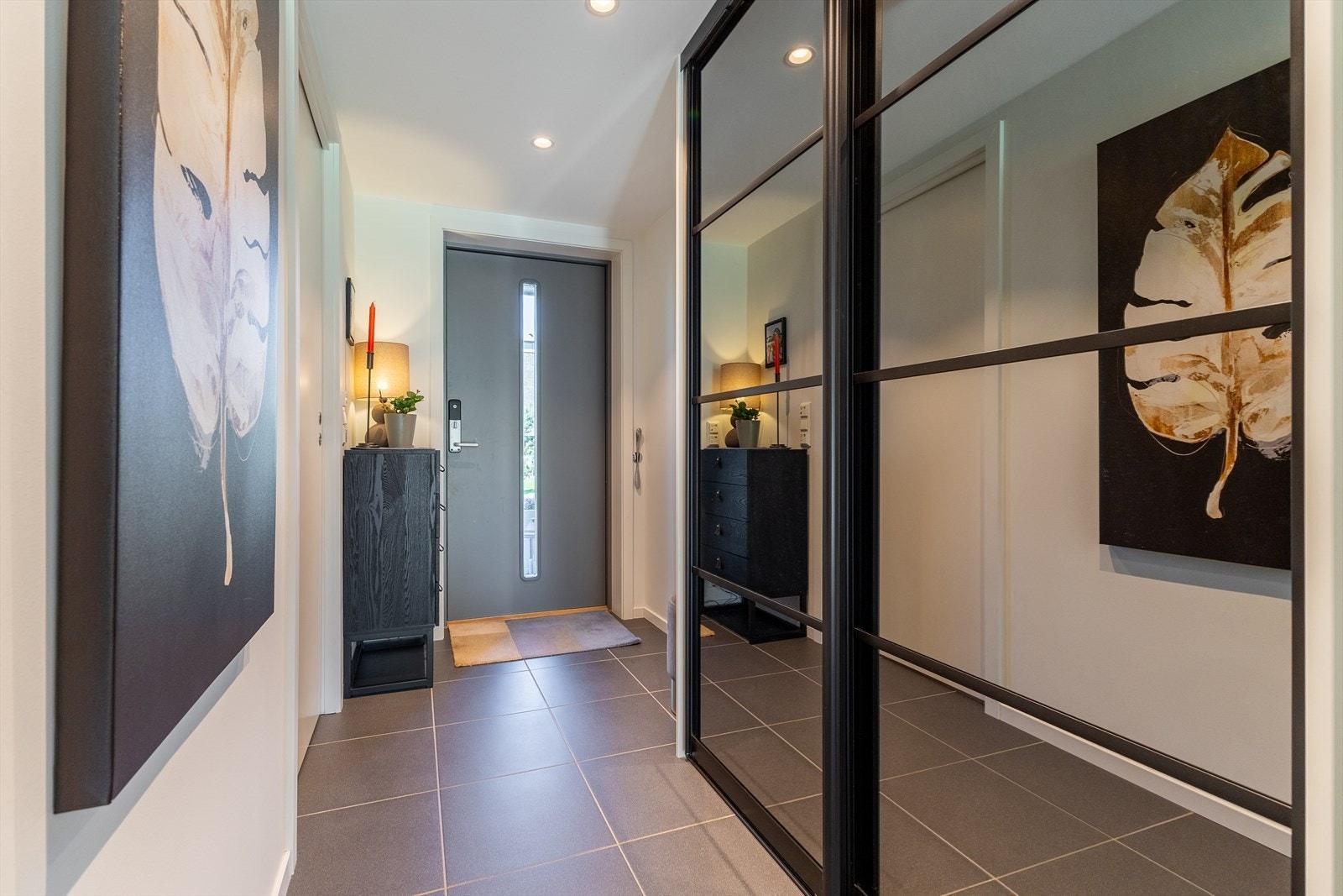 Entréen har flislagt gulv og en romslig skyvedørsgarderobe med speilfronter. Galleribilde