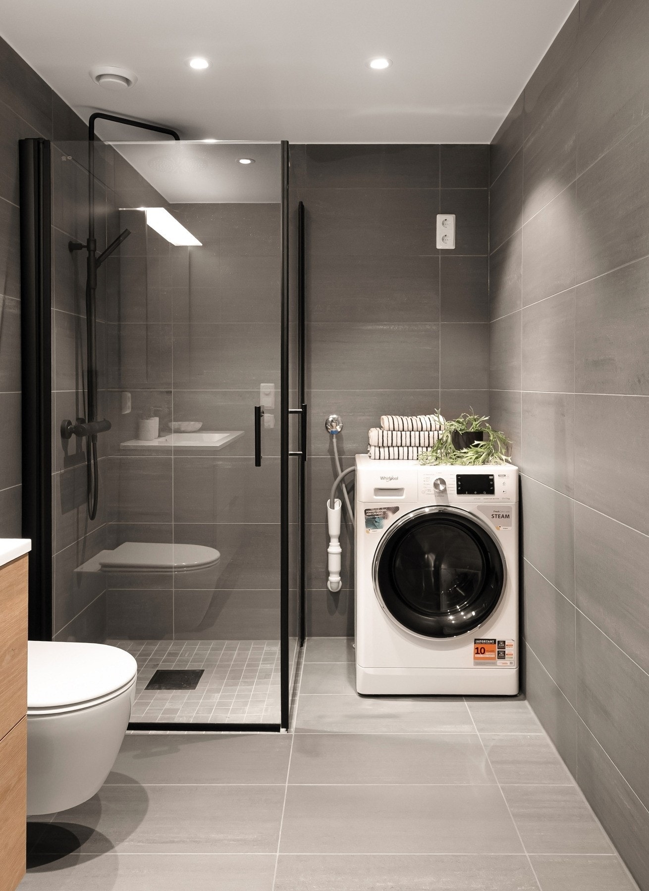 Badet er praktisk innredet med dusjhjørne, vegghengt toalett, servantinnredning med gode oppbevaringsmuligheter og opplegg for vaskemaskin. Galleribilde