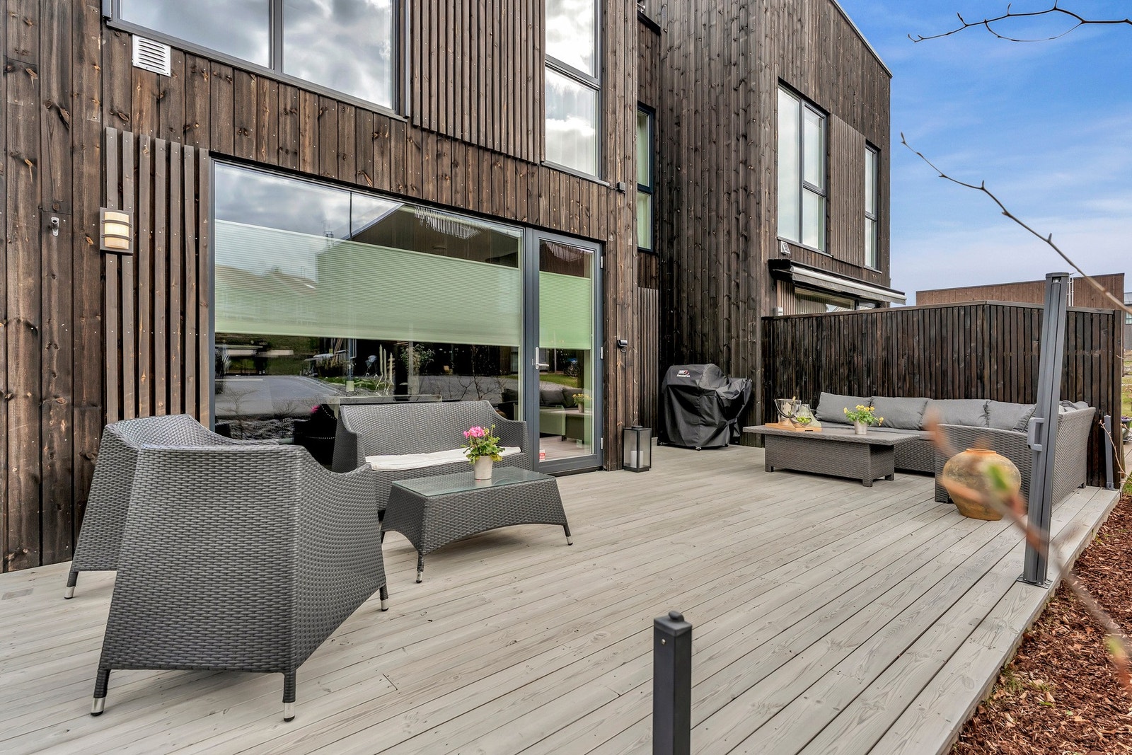 Terrassen skjermes av levegg mot nabo. To vinduer har utvendige screens. Galleribilde