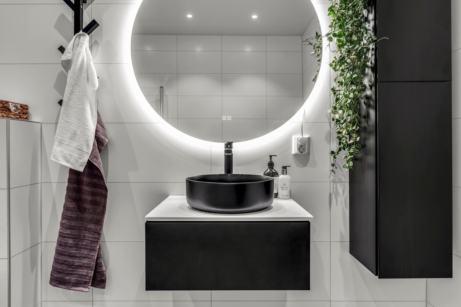 Badet i andre etasje har en elegant innredning med sort, toppmontert servant og speil med belysning i bakkant. Galleribilde