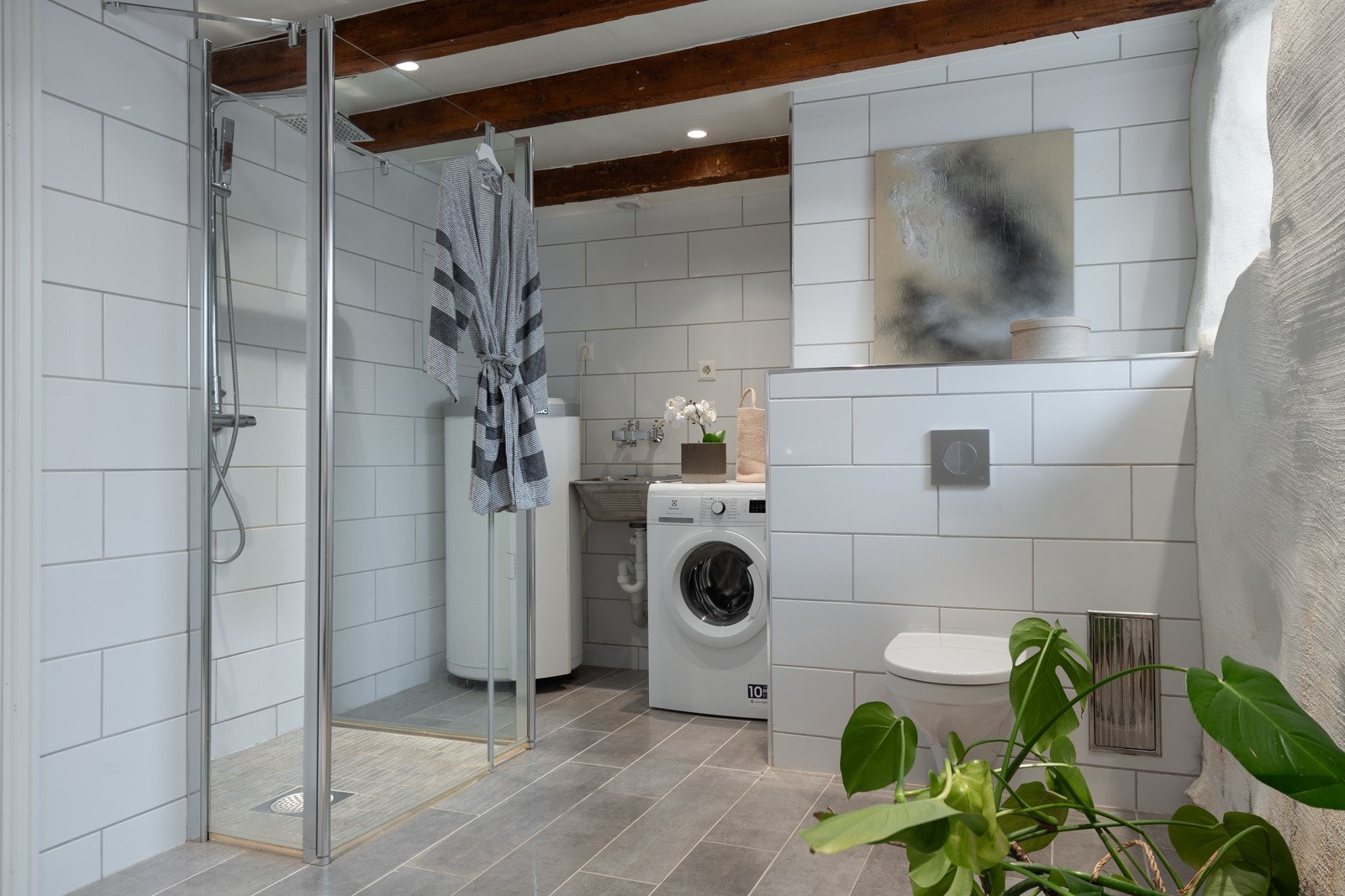 Badet består av innredning med servant, dusjnisje, toalett og opplegg for vaskemaskin. Galleribilde