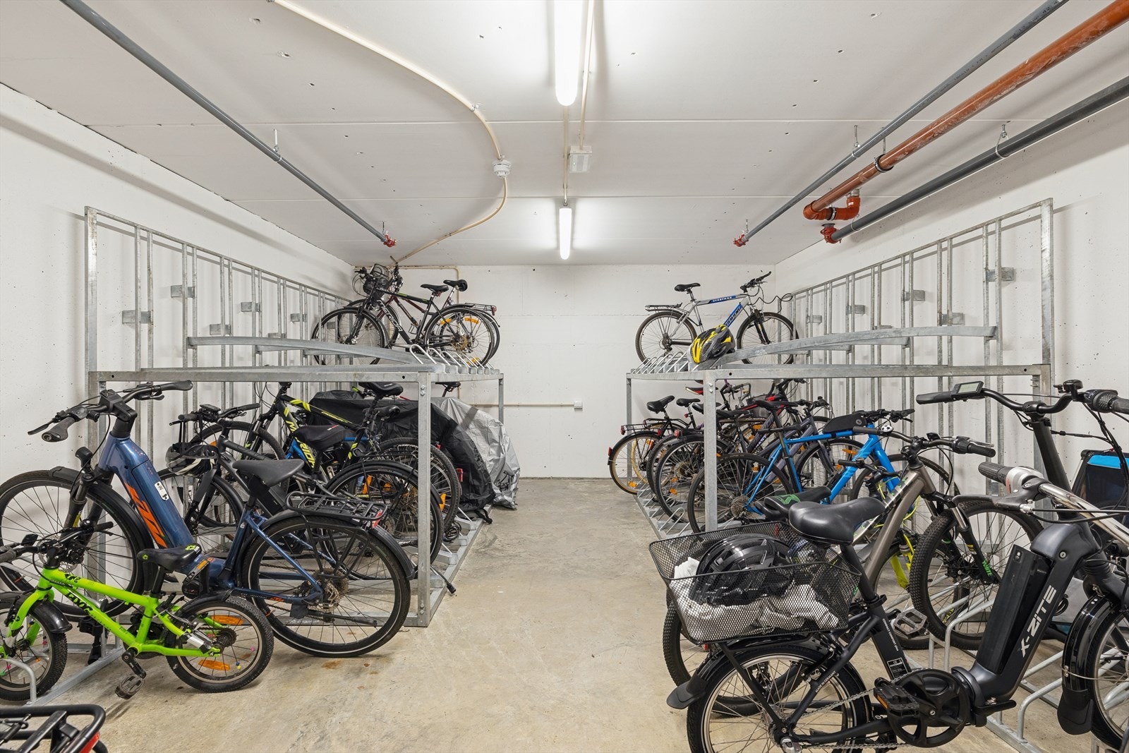 Felles sykkelparkering i underetasjen med egen plass til hver seksjon. Galleribilde