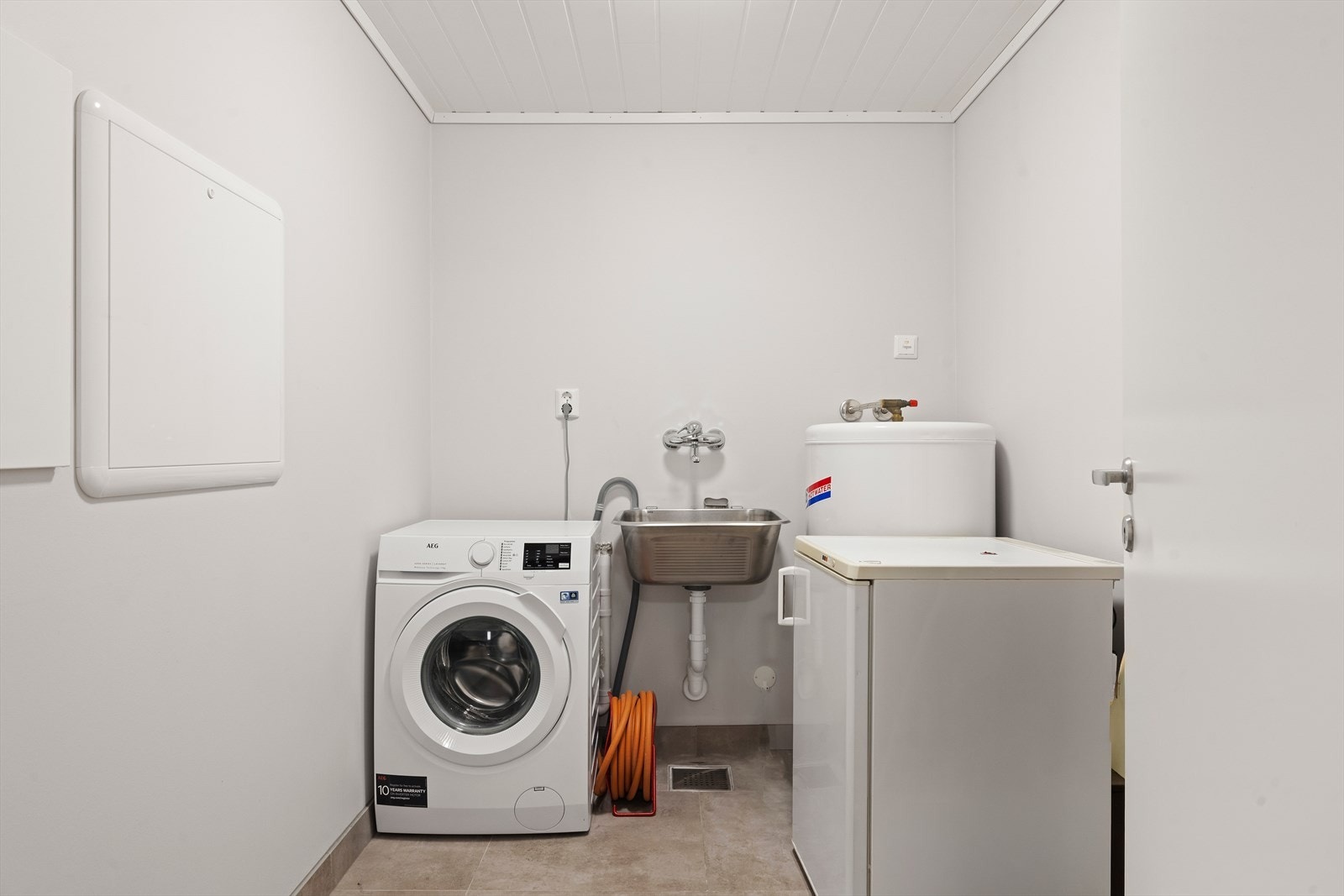 Vaskerom med opplegg for vaskemaskin, utslagsvask, varmtvannsbereder og rør-i-rør vannfordelingsskap. Galleribilde