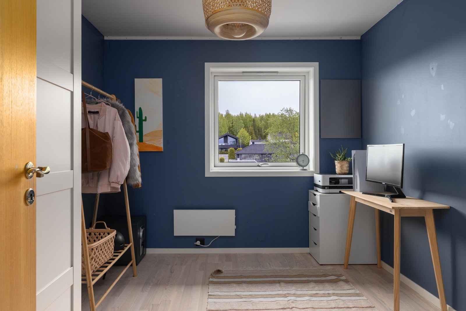 Soverom brukt som kontor. Utsikt ut mot grøntarealer og nabolaget. Galleribilde