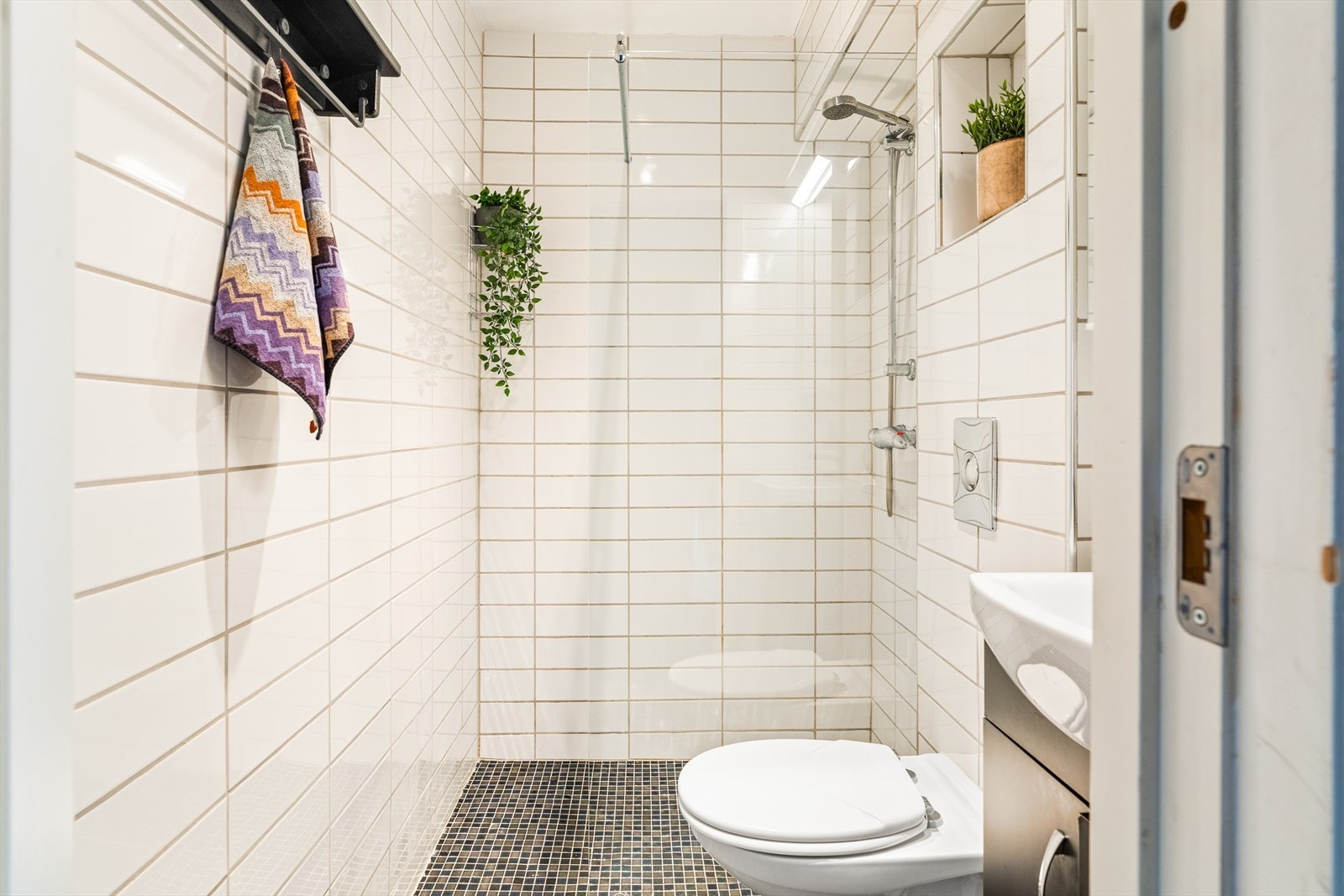 Badet er utstyrt med baderomsinnredning med servant, vegghengt toalett og dusj Galleribilde