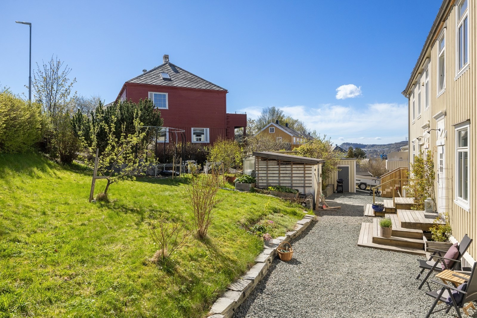 Frodig og grønn hage ved inngangspartiet med sol fra tidlig morgen. Galleribilde