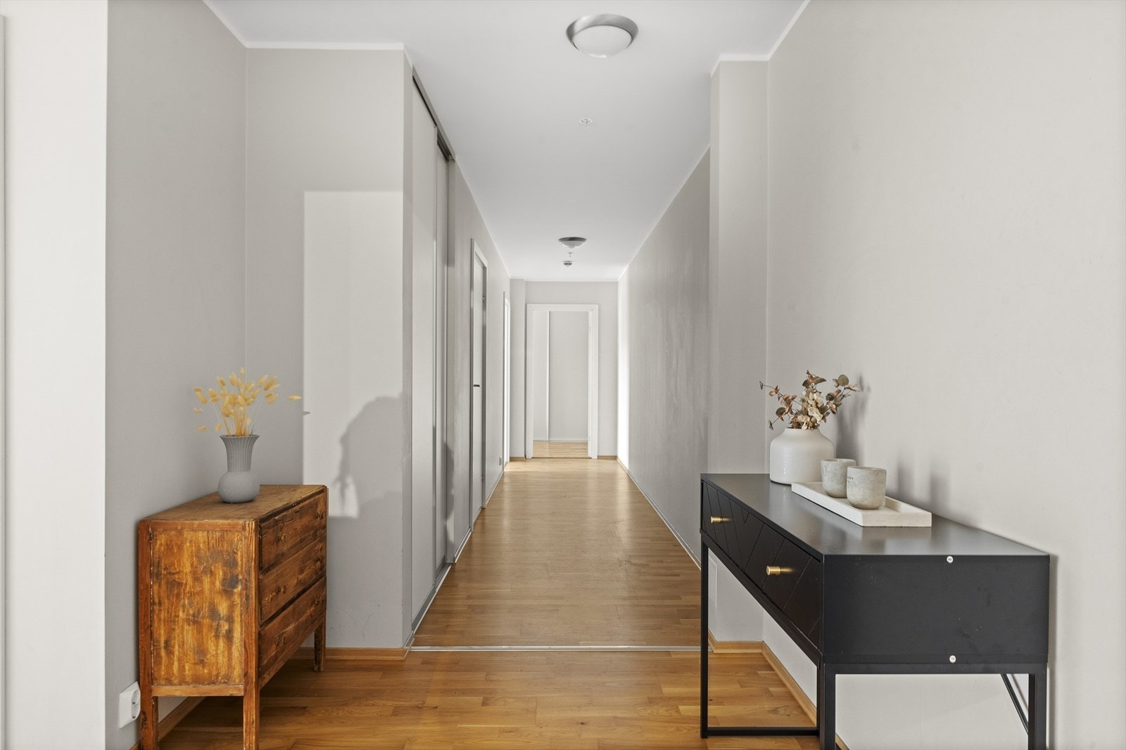 Leiligheten har en meget romslig entré som gir et godt førsteinntrykk. Her er det montert en praktisk skyvedørsgarderobe som gir rikelig med plass til yttertøy og sko. Galleribilde