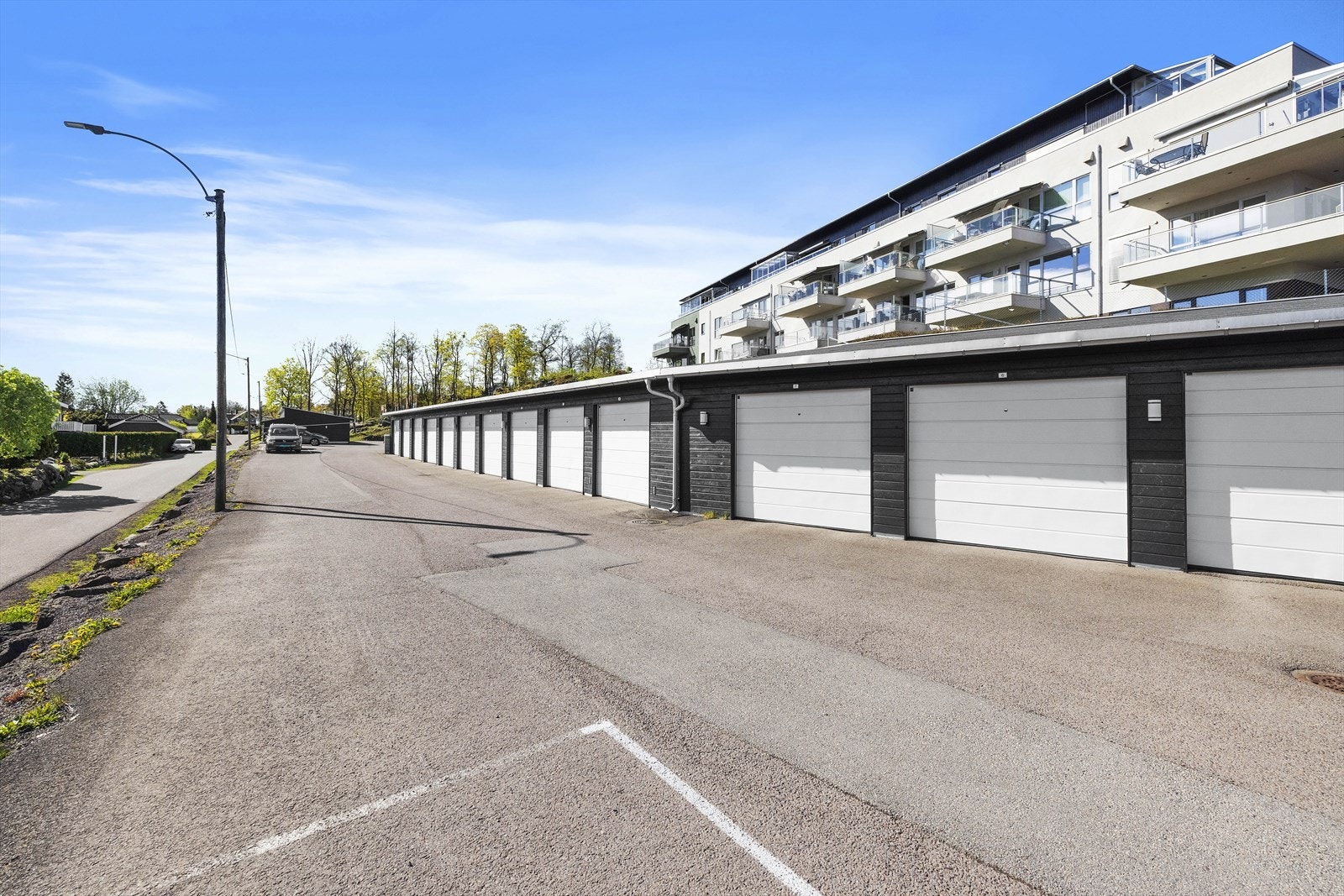 Øst for bygget er det felles garasjeanlegg og biloppstillingsplasser. Galleribilde