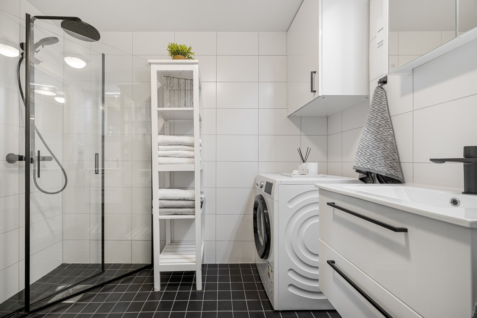 Bad fra byggeår med oppgraderte moderne detaljer i 2026. Rommet har flislagt gulv med gulvvarme og flislagte vegger, samt malte flater i himlingen. Galleribilde