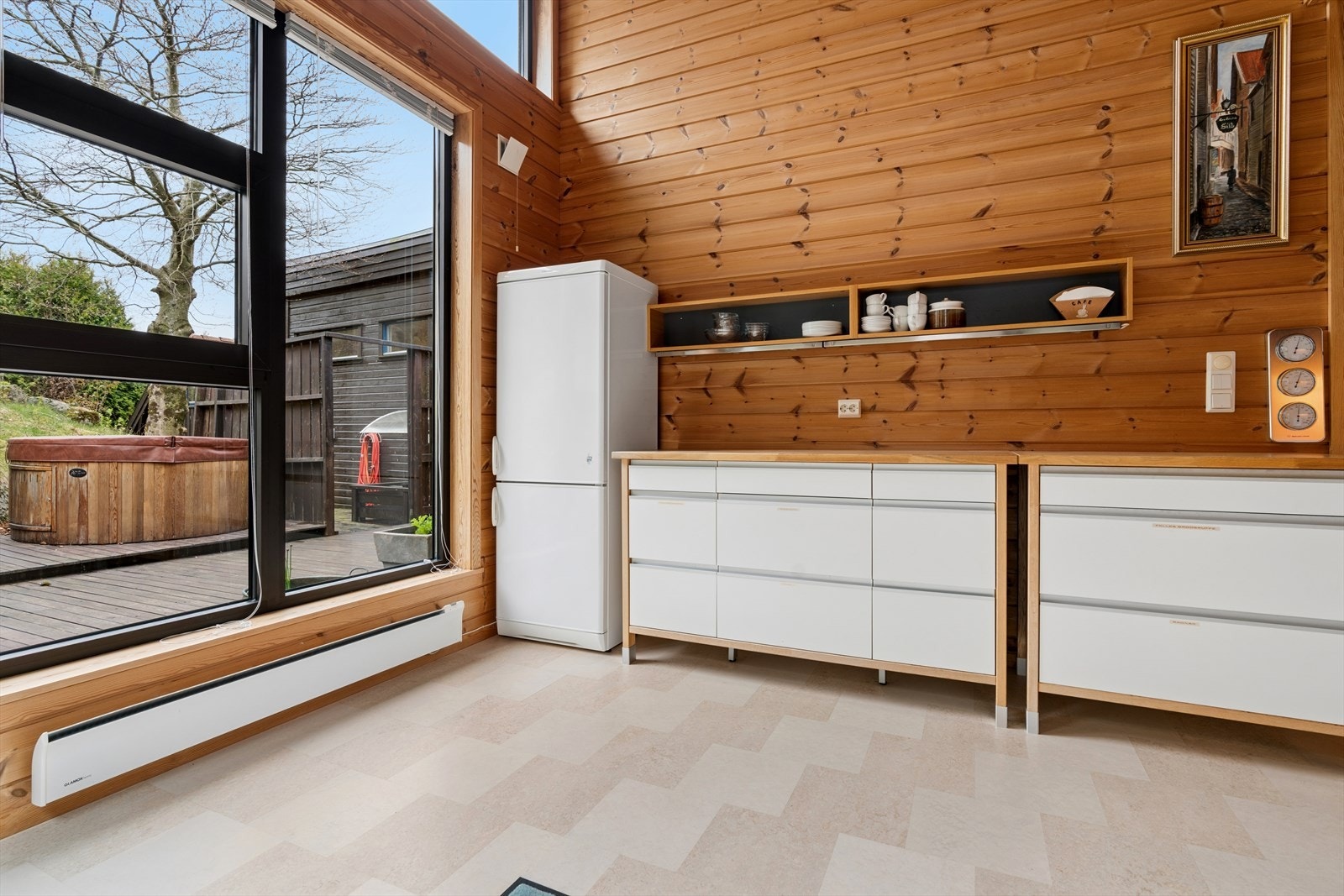 Fra kjøkkenet er det utsikt mot terrassen med utepeis og boblebad. Galleribilde