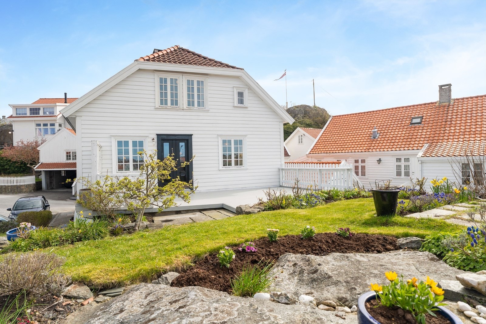 Tomten er sjeldent stor til å ligge i gamlebyen og er pent opparbeidet med stor treterrasse (ikke omsøkt/godkjent), terrasse med betongheller, murer, sti og platting med steinheller, bedd og en herlig hage med diverse beplantning Galleribilde