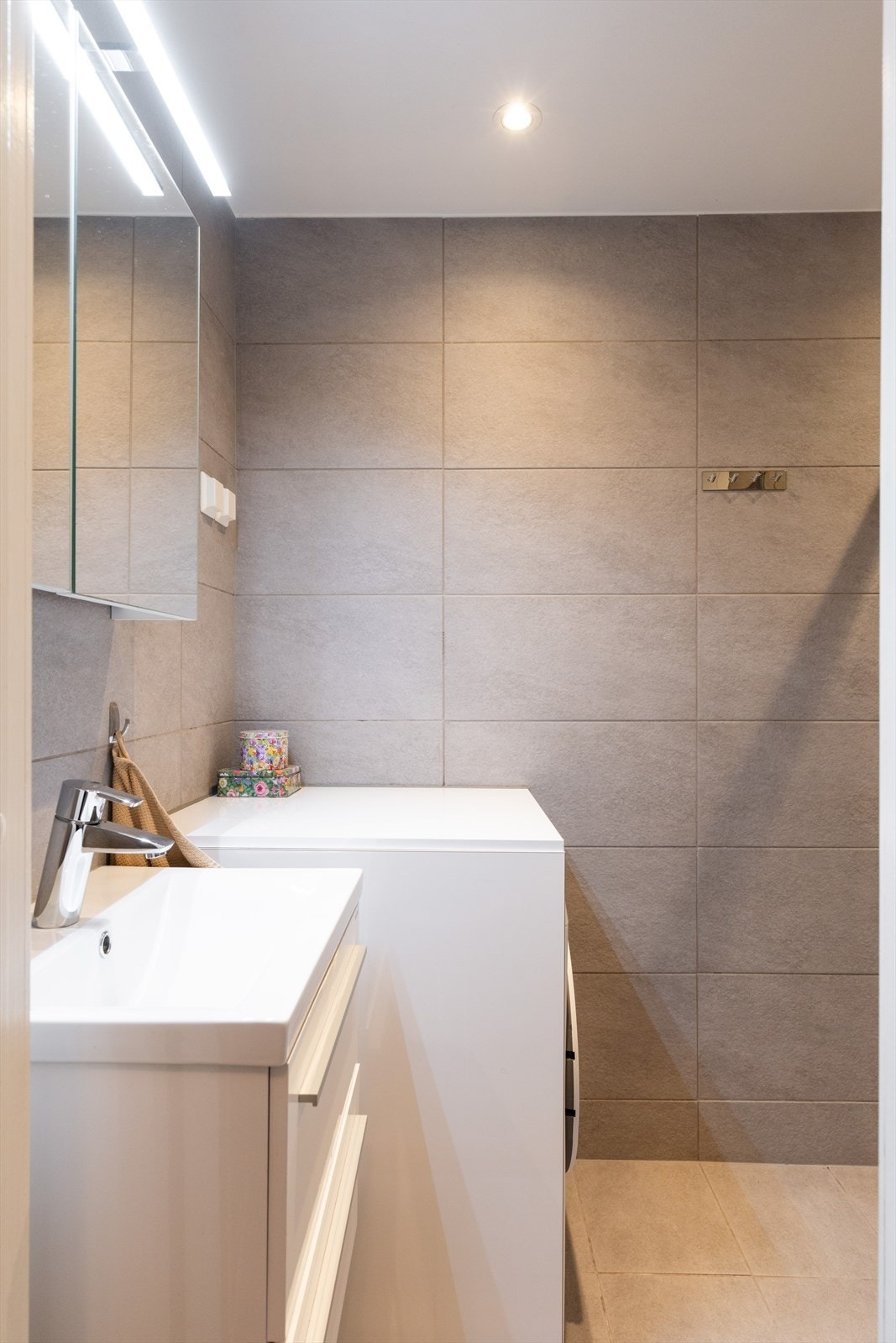 Badet har opplegg for vaskemaskin med praktisk benkeplate over. Galleribilde