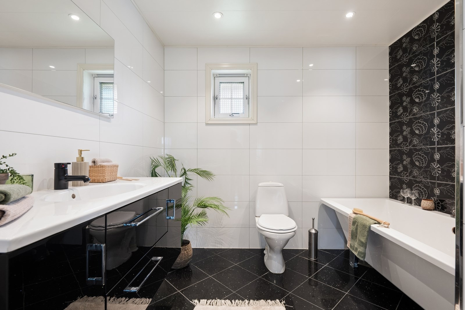 Badet i første etasje har fliser på gulv og vegg, gulvvarme og innfelte lys i himlingen. Overflatene ble fornyet i 2016. Galleribilde