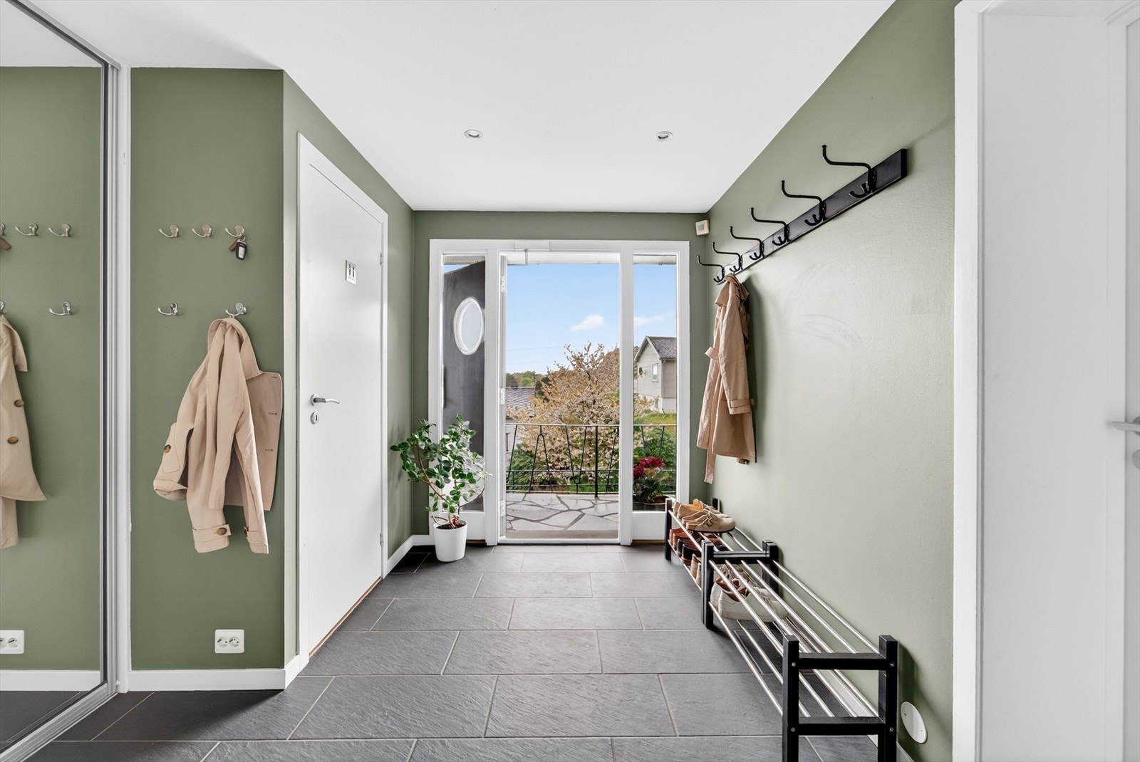 Lys og innbydende gang med avkledningsplass og praktisk skyvedørsgarderobe. Galleribilde