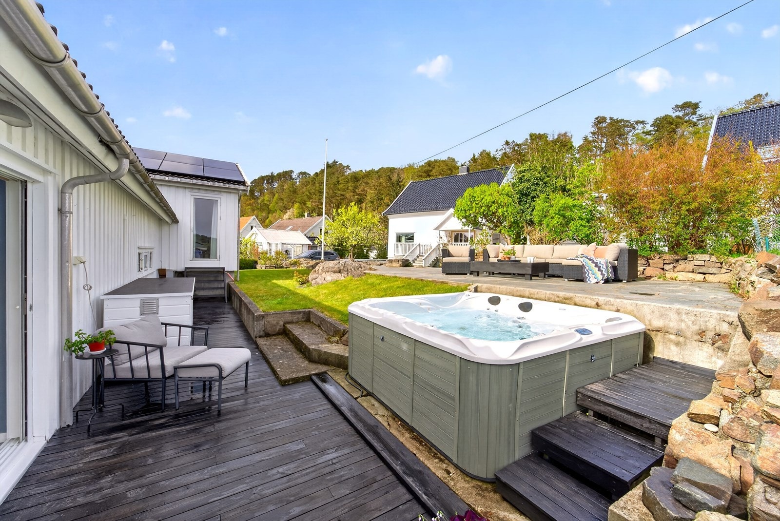 Meget solrikt uteområde med stor støpt platting, treterrasse og jacuzzi. Galleribilde