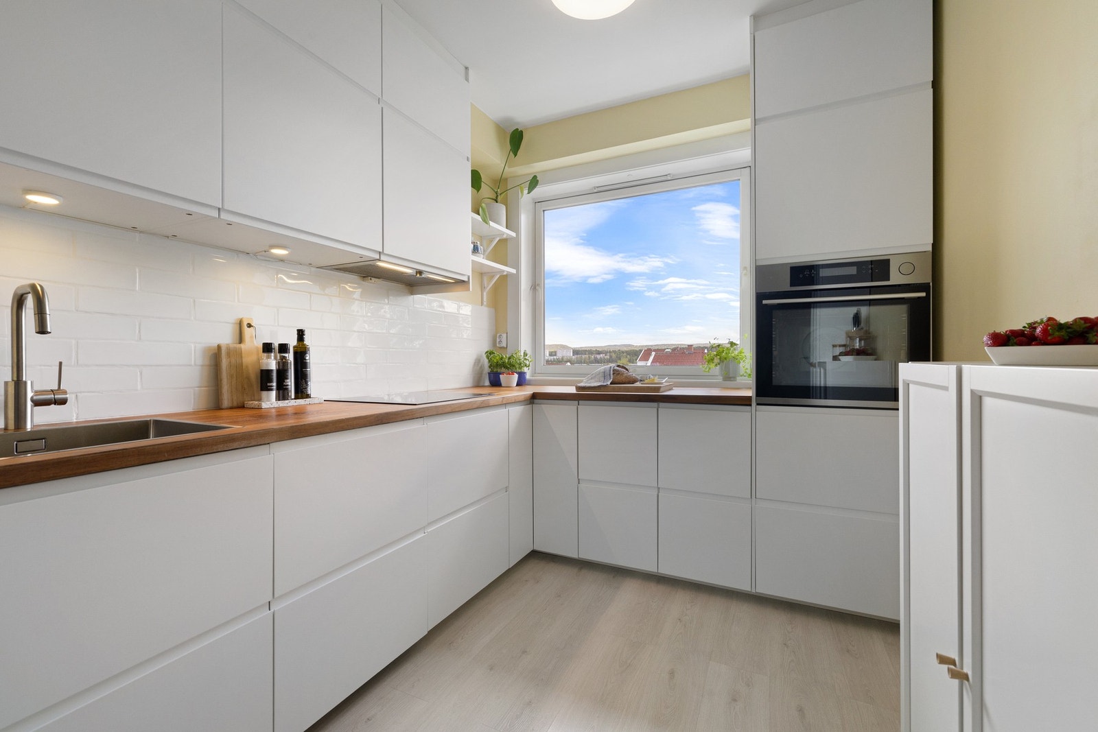 Fin IKEA kjøkkeninnredning fra 2019, med glatte hvite fronter og integrerte håndtak. Galleribilde