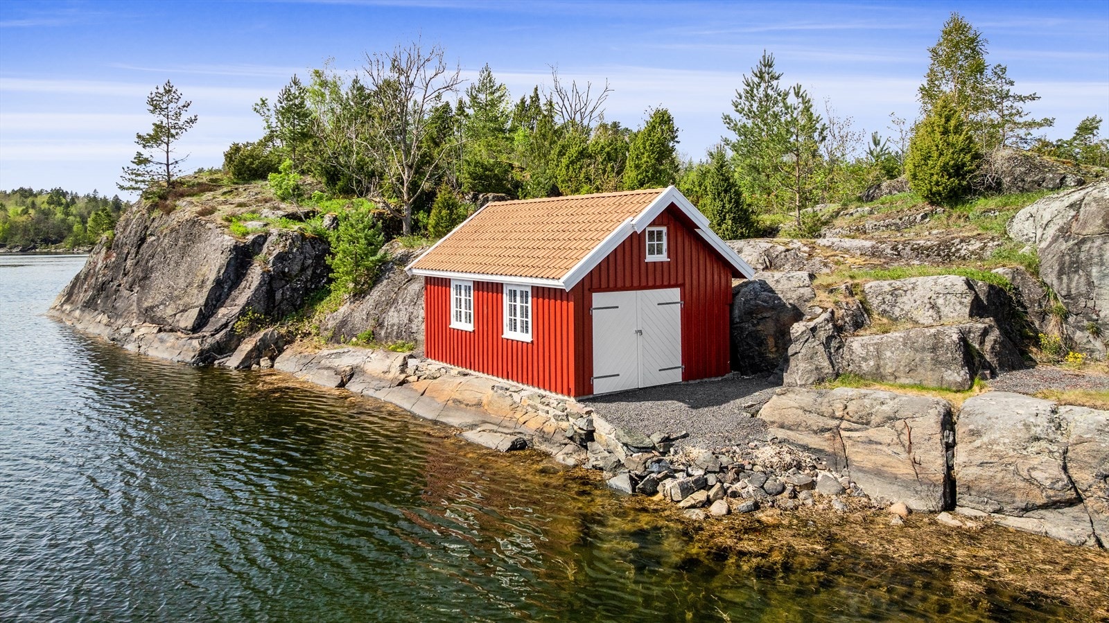 I sjøkanten ligger det en tilhørende sjøbod. Galleribilde