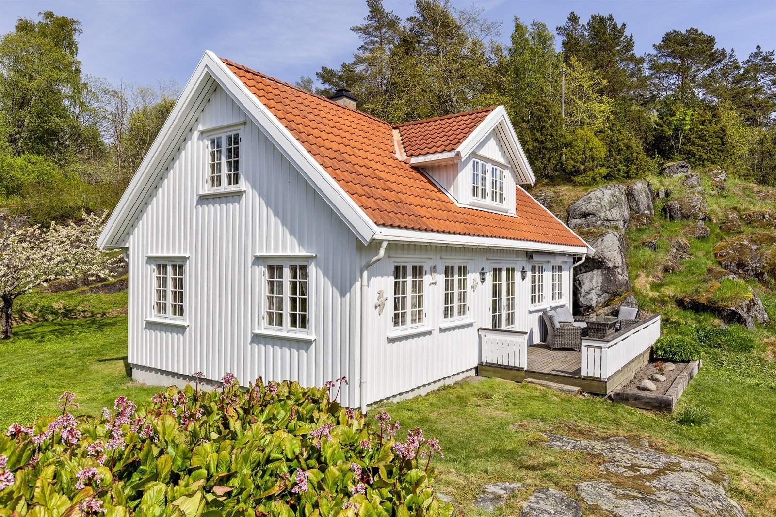Uteområdene er rikt beplantet med blomster, frukttrær og variert vegetasjon. Galleribilde