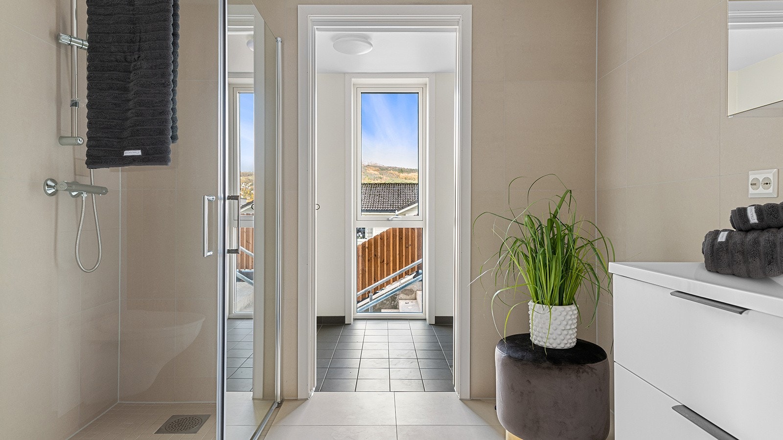 Moderne bad med fliser på både gulv og vegg. Fra badet har man skyvedør inn til separat vaskerom. Galleribilde