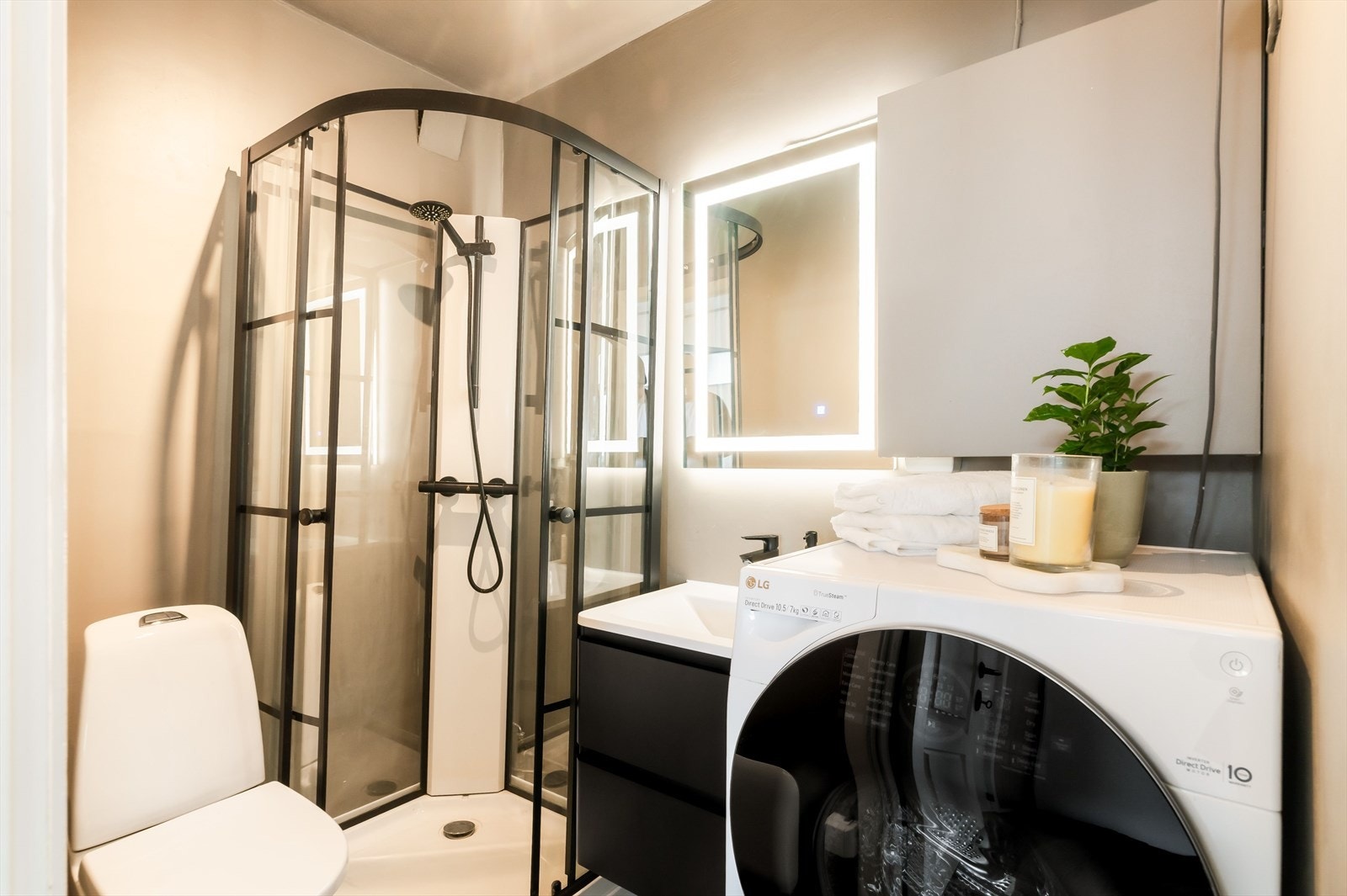 Badet har toalett, dusjkabinett servantskap og lysspeil. I tillegg til opplegg for vaskemaskin. Galleribilde