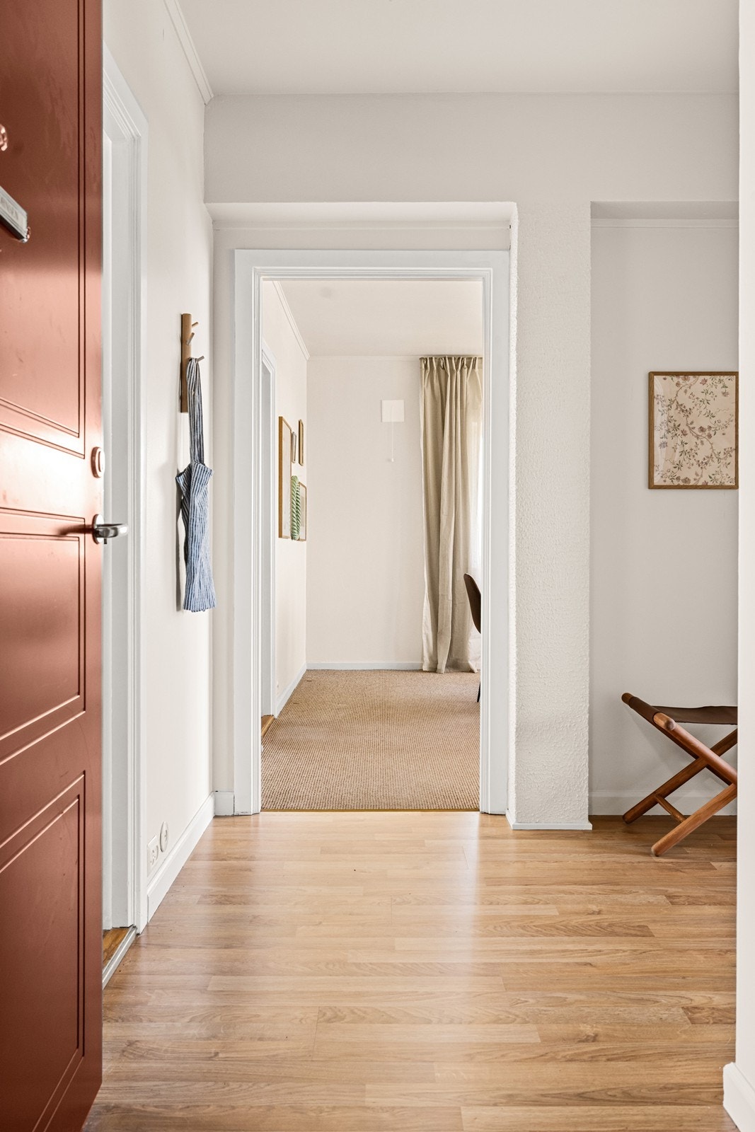 Gangen binder leilighetens rom sammen, med en glassdør som åpner inn mot stuen. Galleribilde