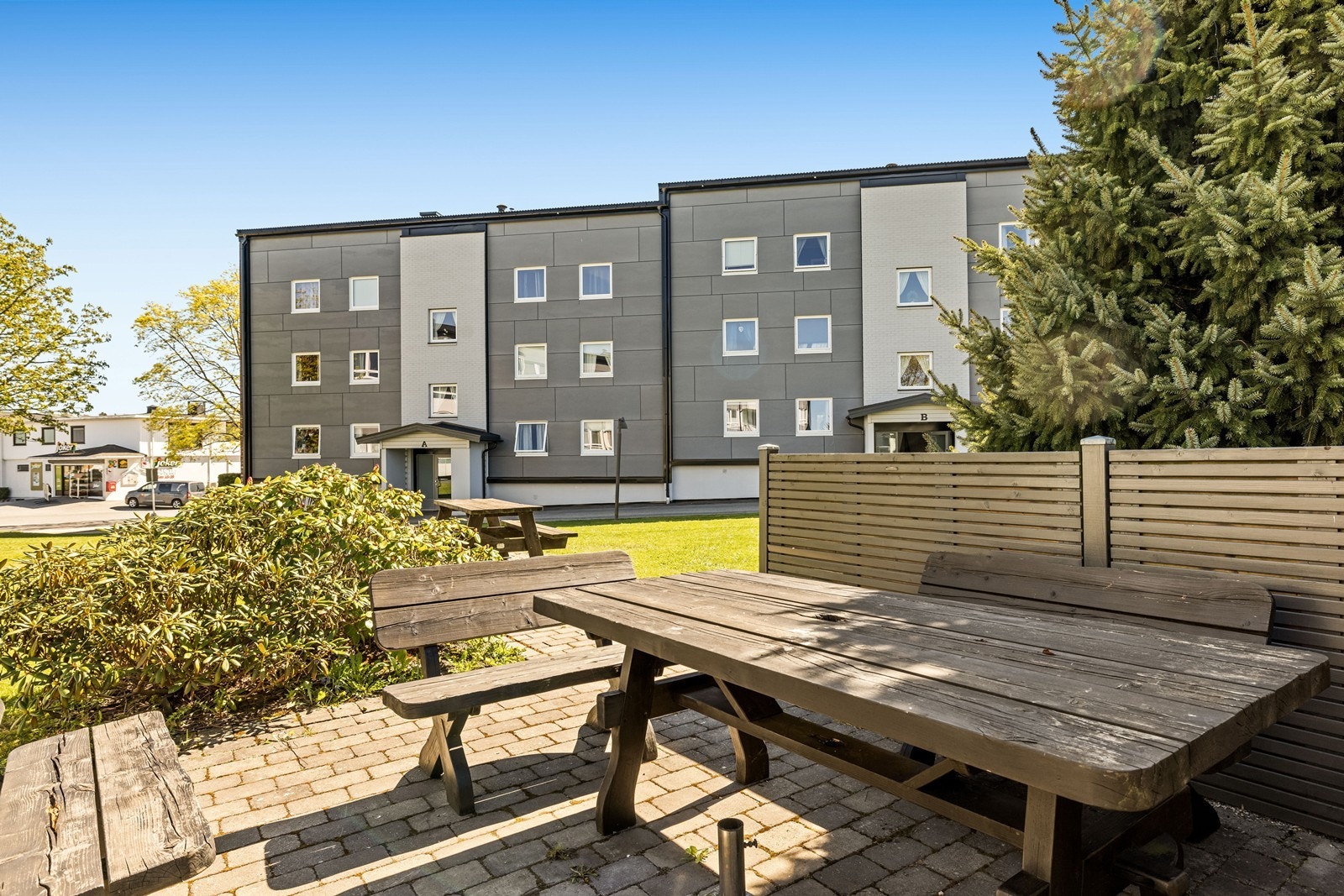Felles, koslige uteområder med sittegrupper og gressplen, pent opparbeidet for beboerne. Galleribilde