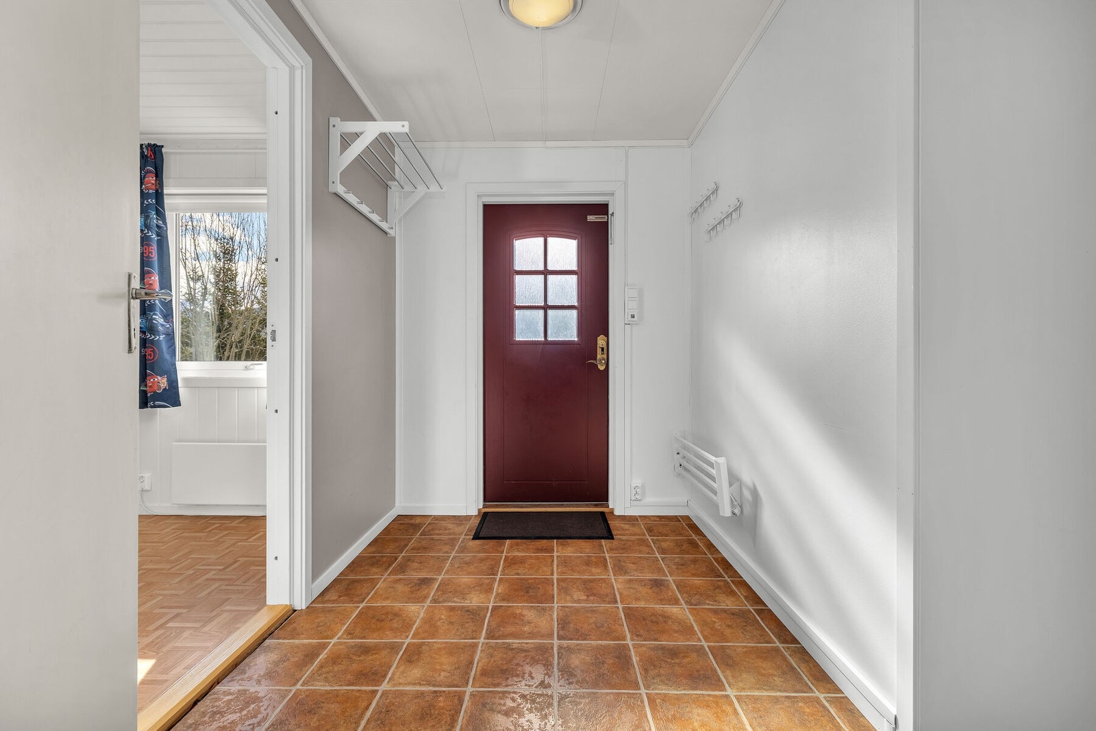 Praktisk entré med flislagt gulv og plass til å henge fra seg yttertøy. Galleribilde