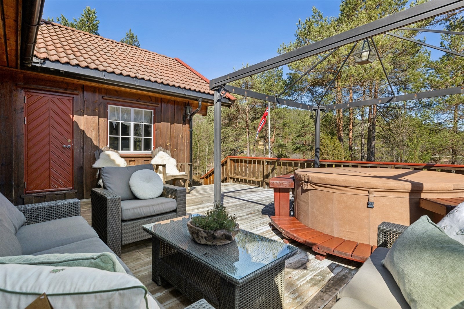 En av hyttas to romslige terrasser, med god plass til både sittegruppe og boblebad. (Boblebad medfølger i salget) Galleribilde