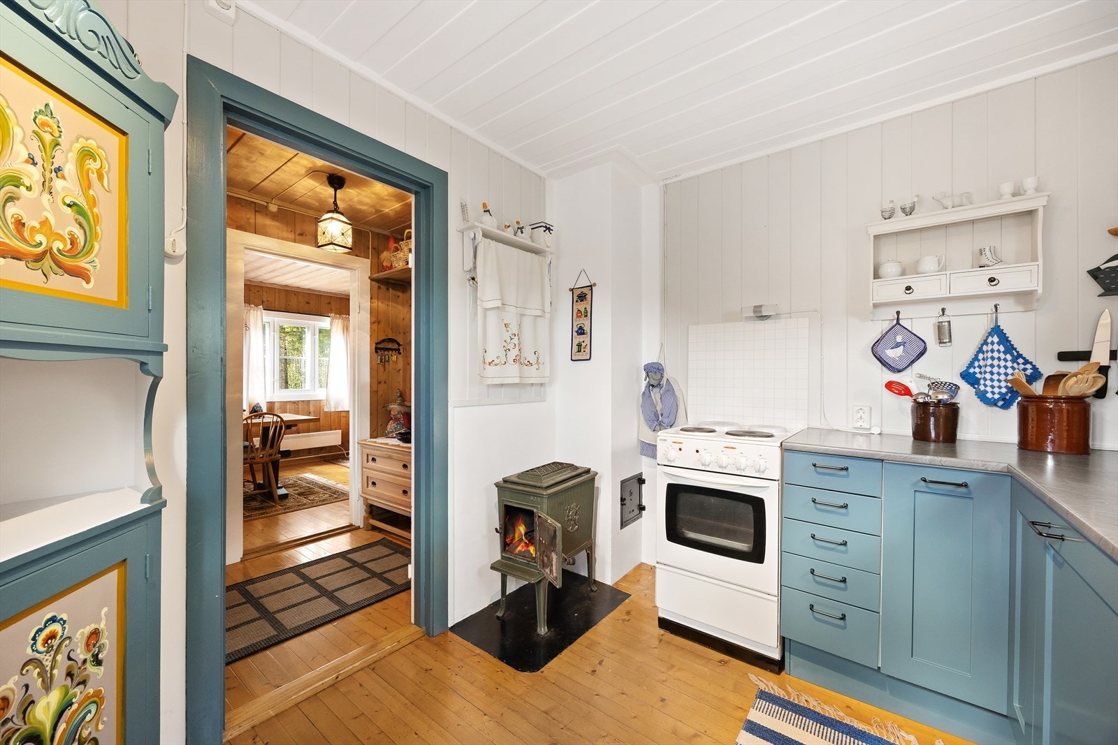 Kjøkkenet er har en funksjonell innredning med glatte fronter og benkeplate i laminat, kjøleskap, komfyr med koketopp og backsplash. Galleribilde