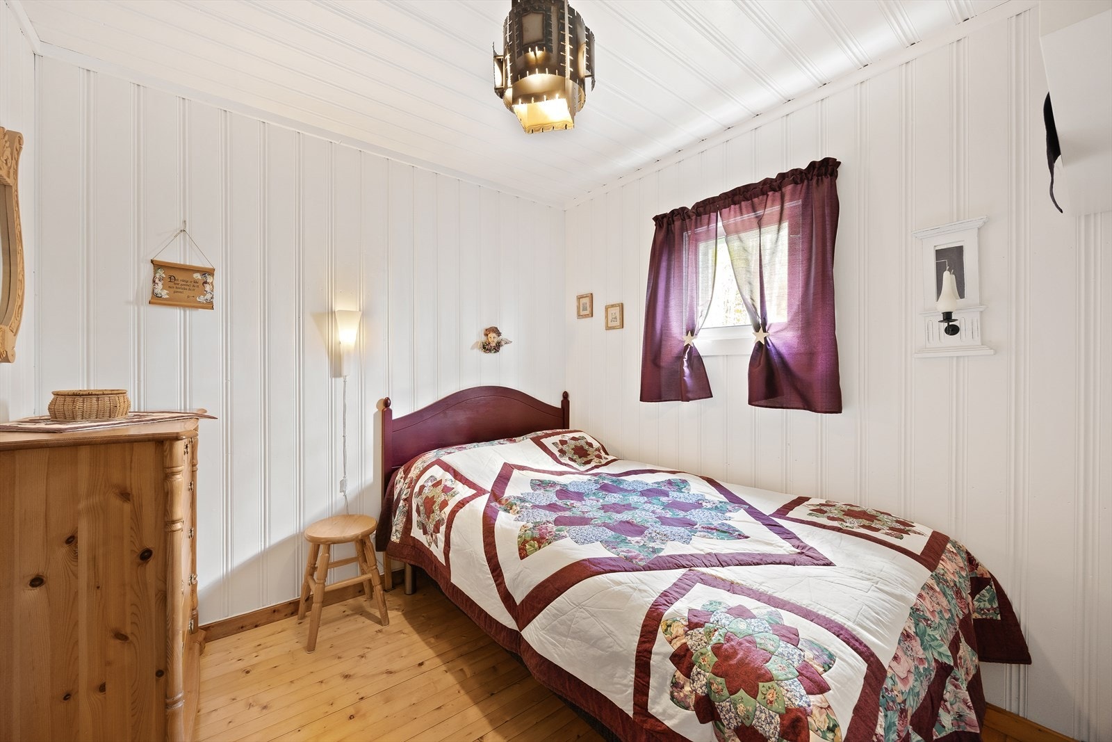 Et lyst og trivelig soverom med trepanel på gulv og vegger. Galleribilde